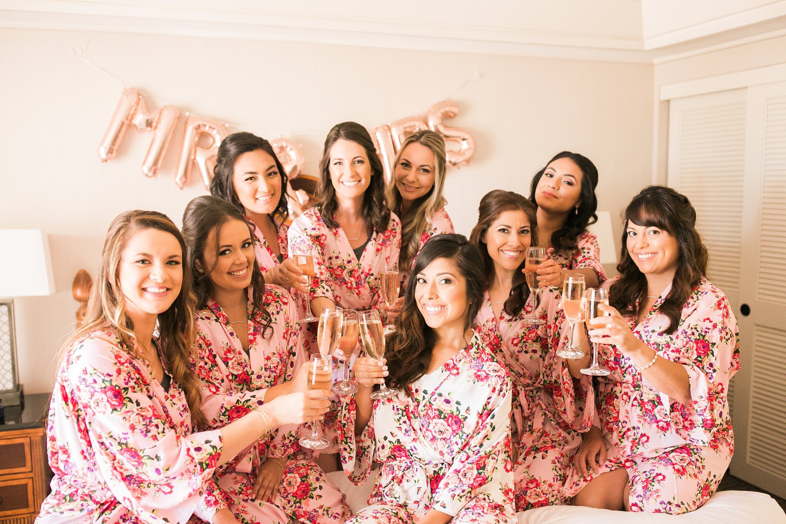 www.santabarbarawedding.com | Kelsey Crews Photo | Hilton Santa Barbara Beachfront Resort | Bride and Bridesmaids in Pink Robes Drinking Rosé Wine Before Ceremony 