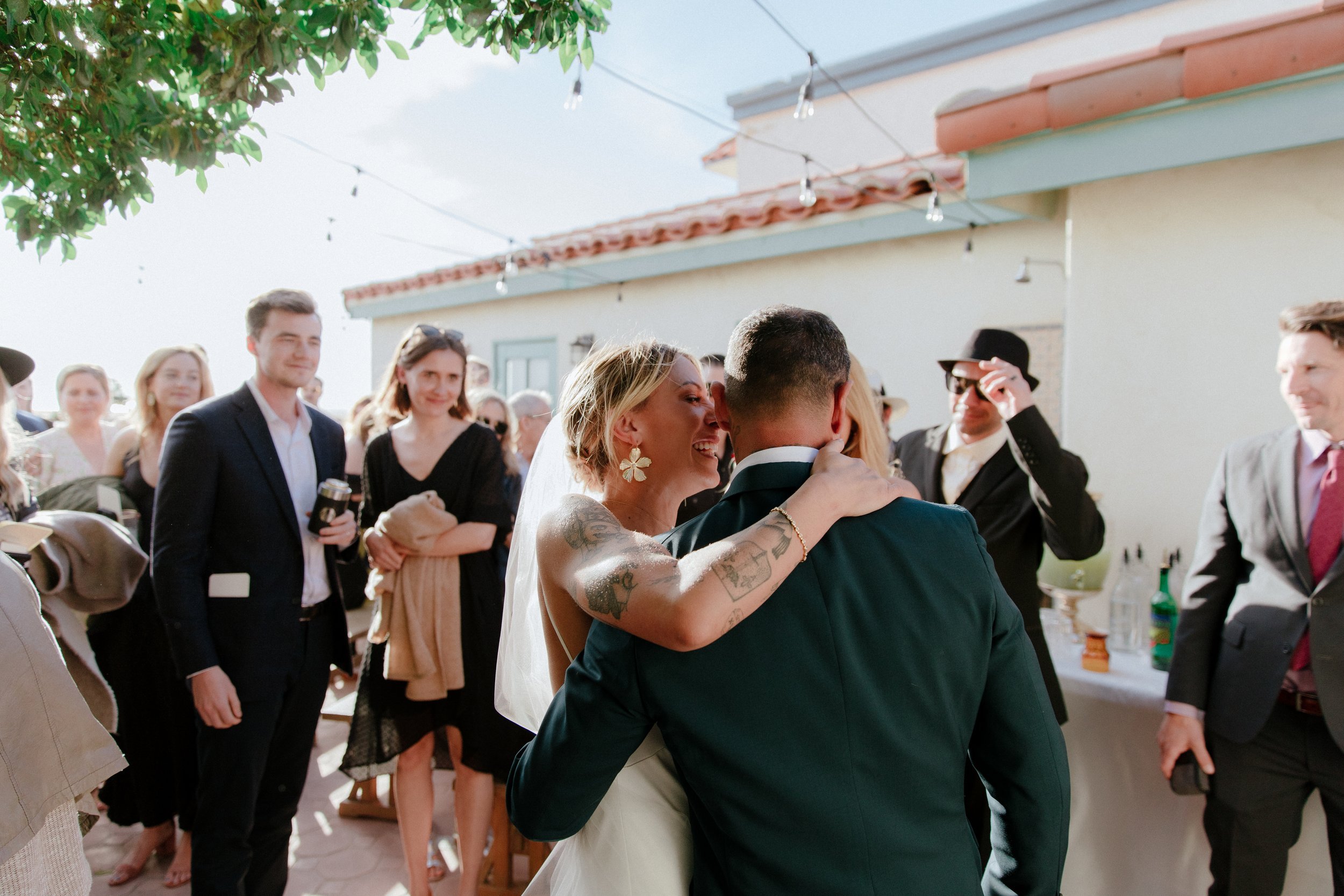 www.santabarbarawedding.com | Chris J. Evans | Paul Smith Suits | Couple Embracing Surrounded by Guests After the Ceremony 