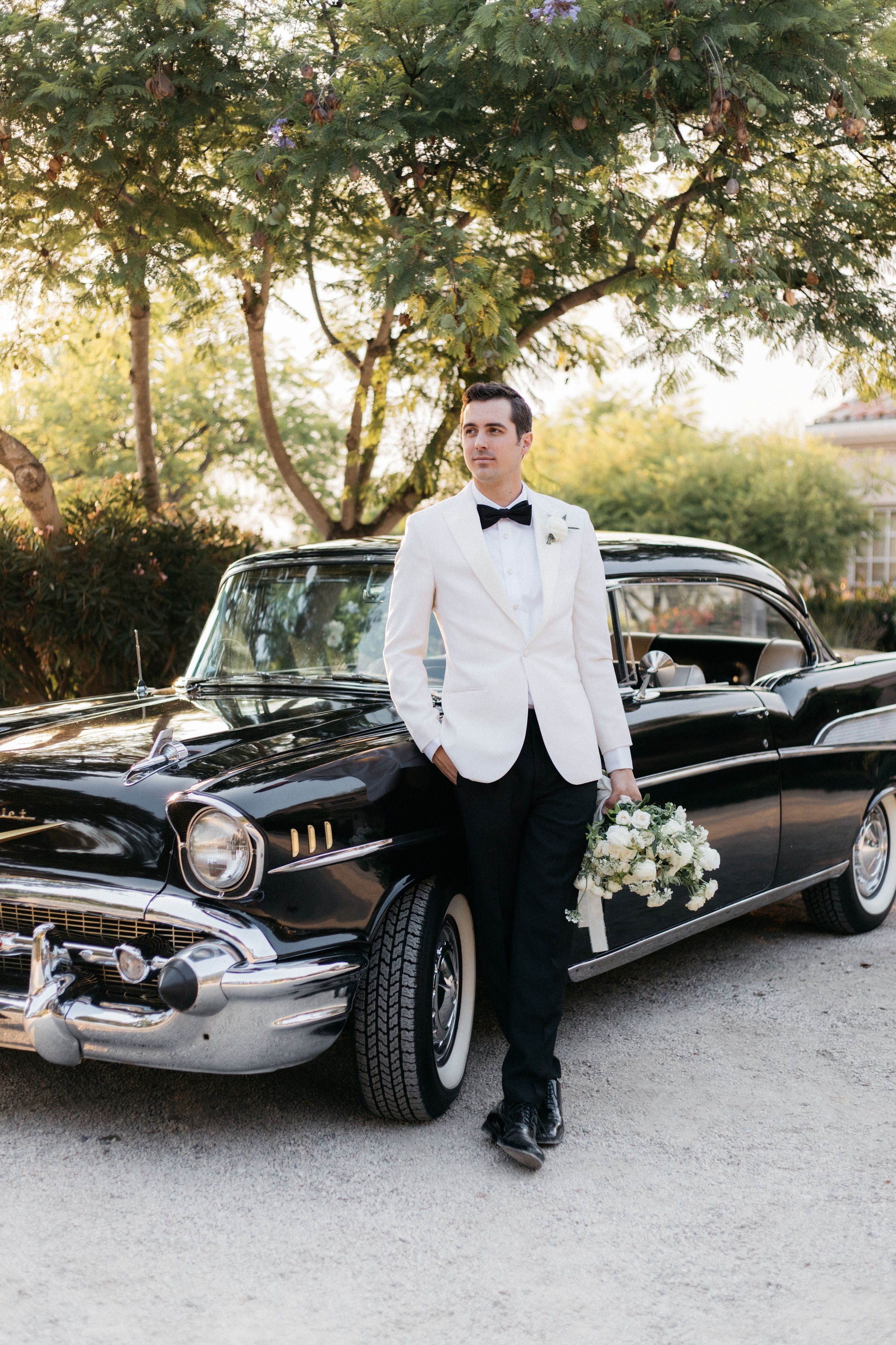 www.santabarbarawedding.com | Villa Verano | Alexander Thomas | Amie Brie Events | Luxe Transportation | Knot Just Flowers | Groom Standing Against Black Car Holding Bouquet