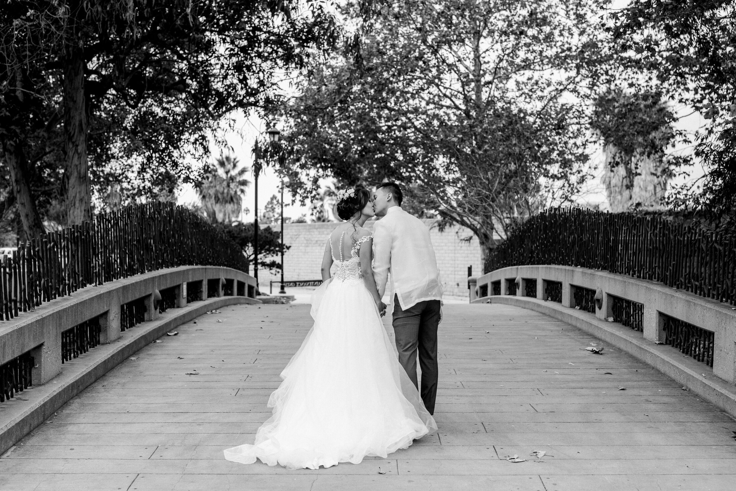 www.santabarbarawedding.com | Chase Palm Park | Anna Delores Photography | Bride and Groom Kiss on a Bridge in the Park