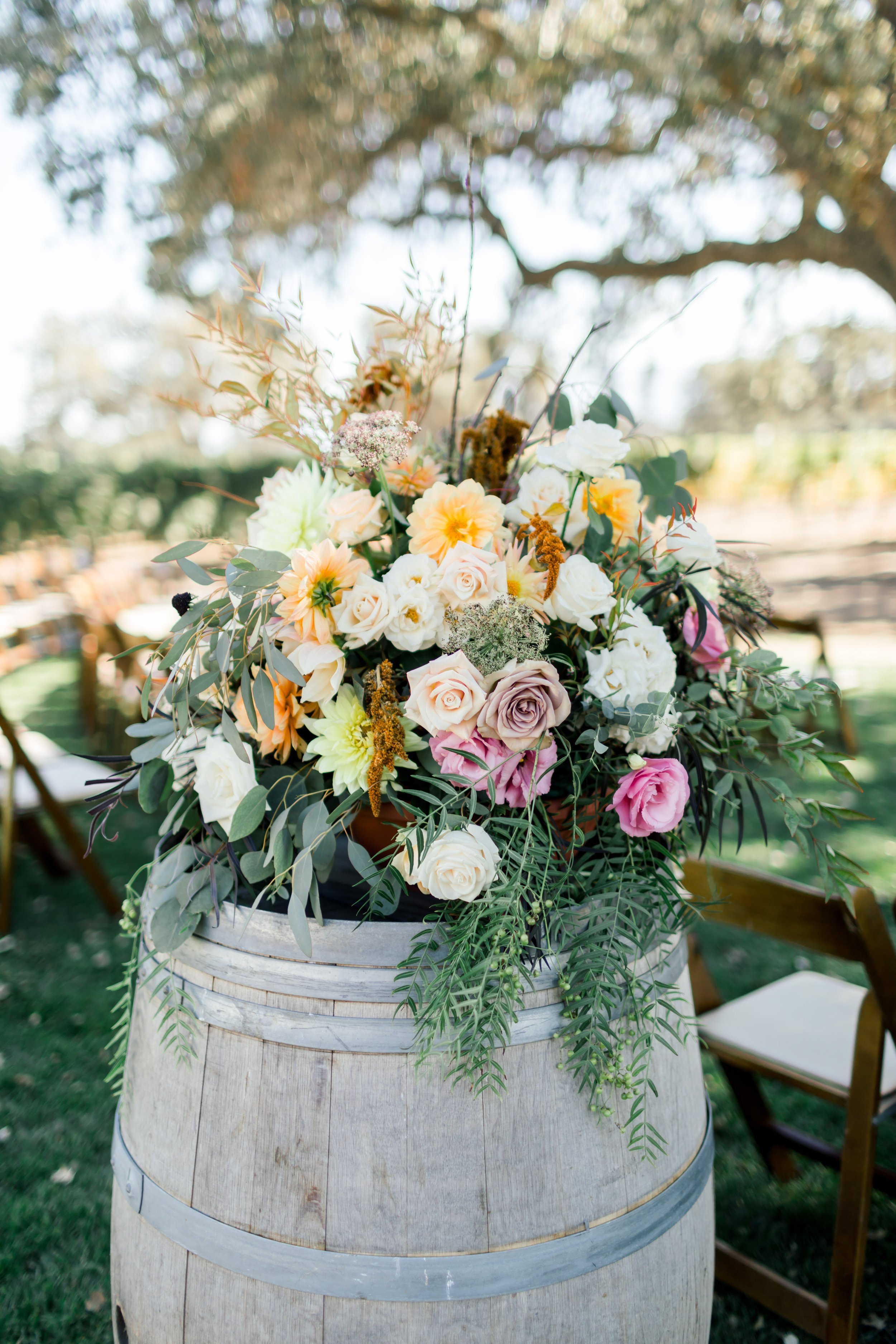 www.santabarbarawedding.com | Margaret Joan Florals | Aura Elizabeth Photography | Pink, White, and Yellow Flowers on a Barrel at the Start of the Ceremony Aisle