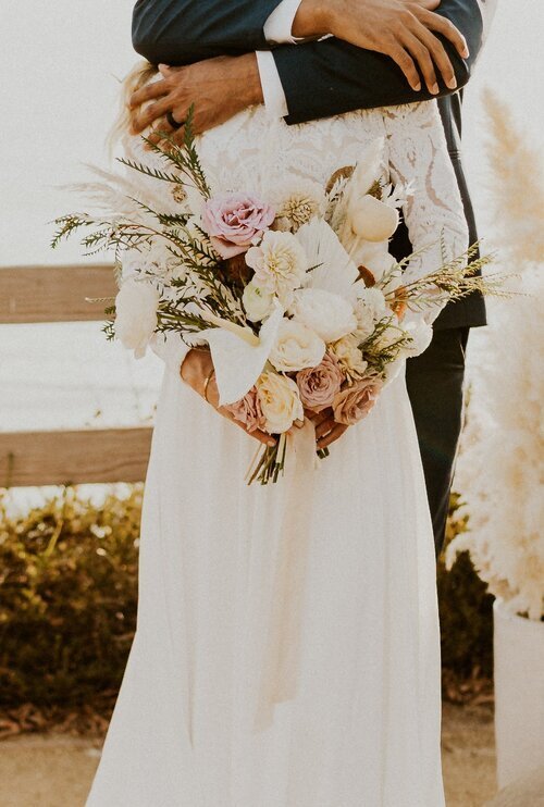 www.santabarbarawedding.com | Gage Allen Photography | Boho Chic Dreams | Bride and Groom Embracing with Bride’s Bouquet