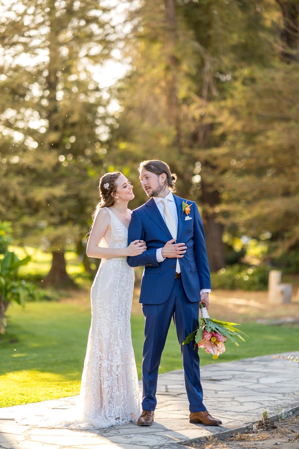 www.santabarbarawedding.com | Santa Barbara Courthouse | Elizabeth Victoria Photography | Hogue &amp; Co. | Floravere | La Rouge Artistry | Bride and Groom Embracing Outside by the Trees