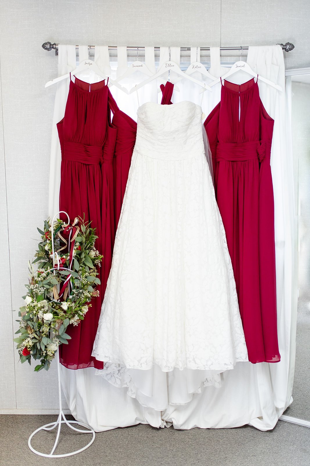 www.santabarbarawedding.com | Jocelyn &amp; Spencer | Woodland Events | Wedding Gown Hanging Next to Two Red Bridesmaid Dresses