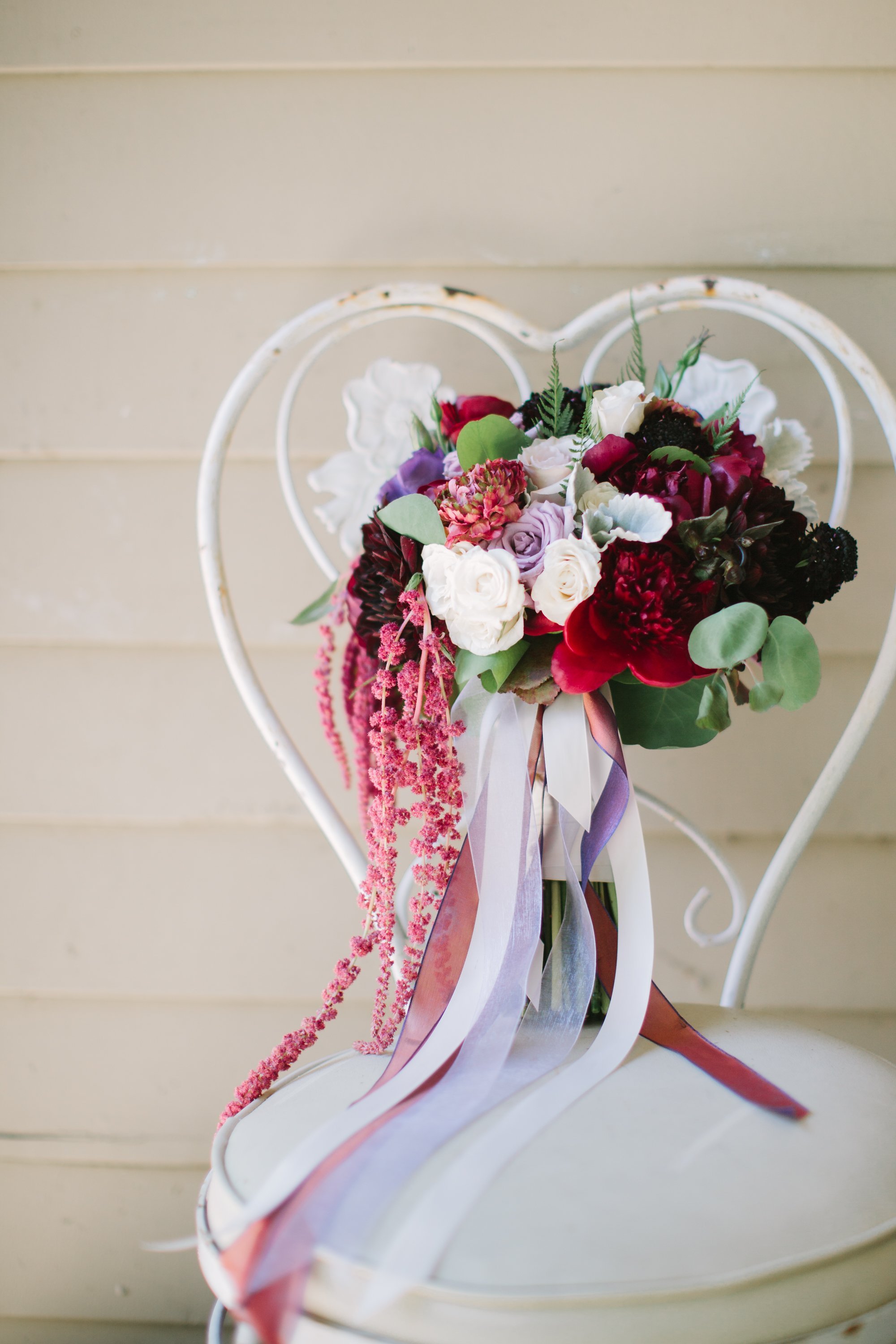www.santabarbarawedding.com | Winter Creative Co. | A Beautiful Day Productions | Bouquet of Red and White Flowers on Heart-Shaped Chair