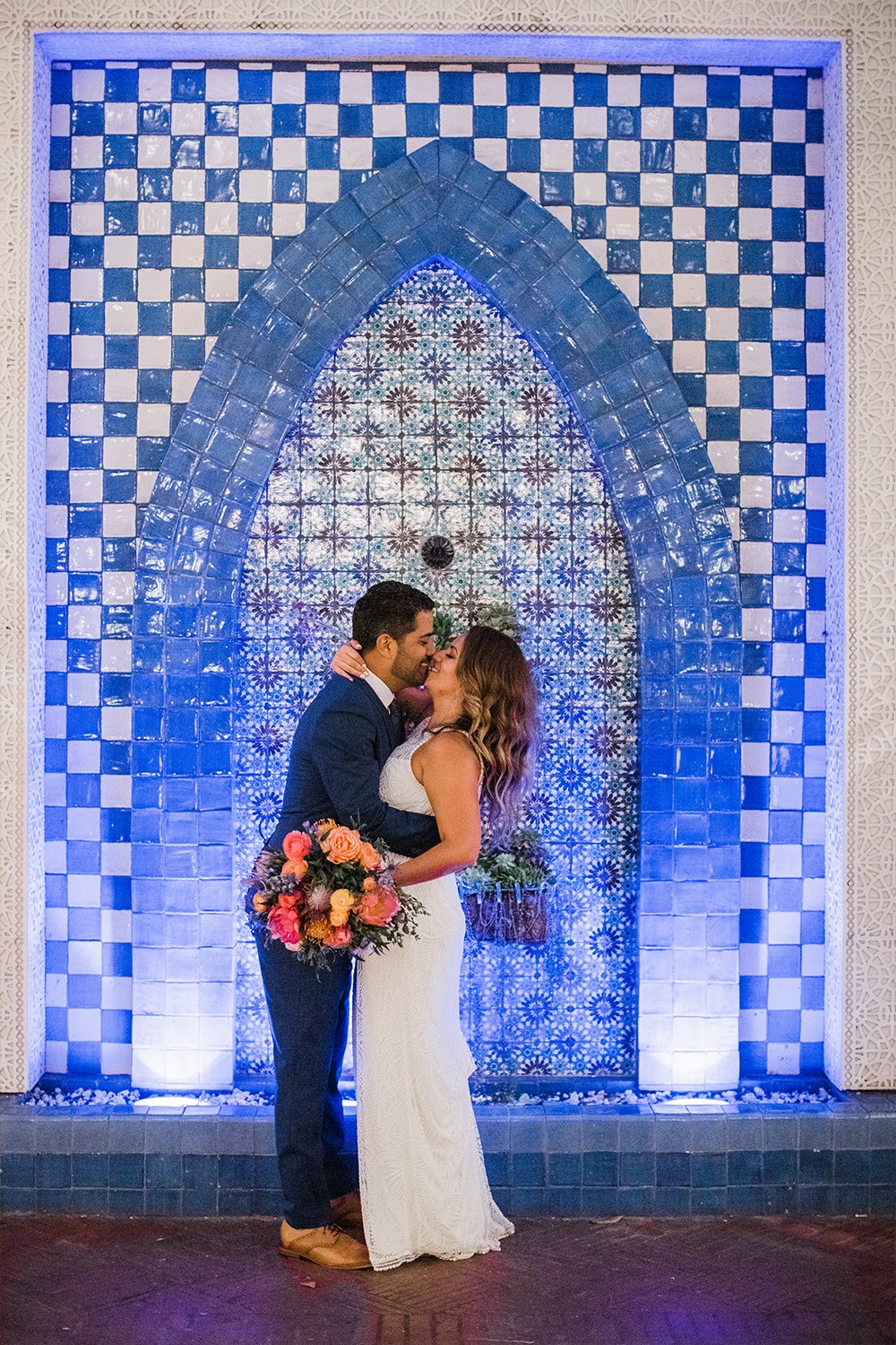 www.santabarbarawedding.com | Michael + Anna Costa Photography | Kimpton Canary | SB Courthouse | LuckEleven Events | Emma Rose Floral | Couple Kiss in Front of Patterned Blue Background