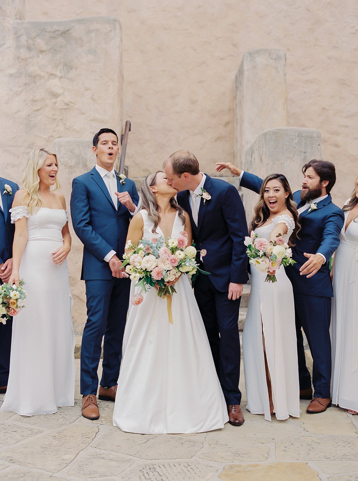 www.santabarbarawedding.com | Kelsey Rae Designs | Our Lady of Mount Carmel | Dani Toscano | Alexis Ireland Florals | Jenny Yoo | Reformation | Ted Baker | Couple Kiss in Front of Wedding Party