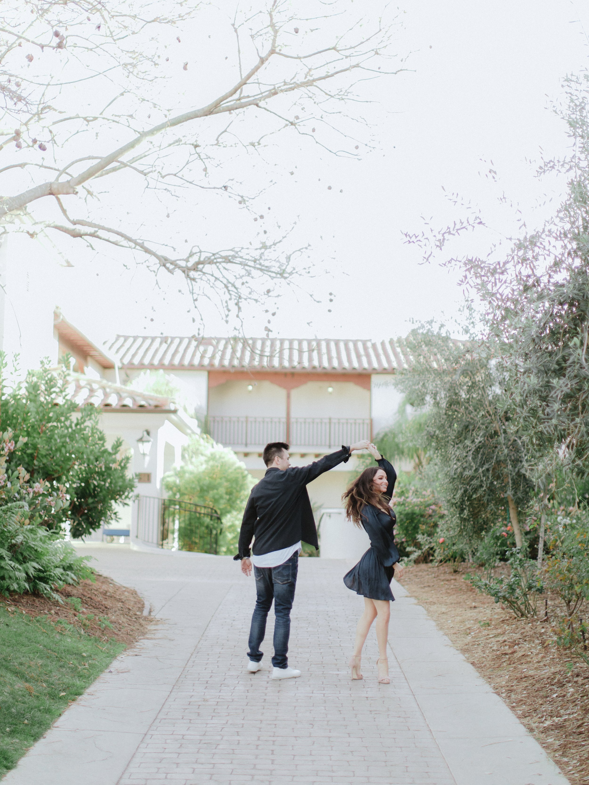 www.santabararawedding.com | Chris J. Evans | Santa Barbara Ritz-Carlton Bacara | Couple Twirling on the Walkway Between the Trees