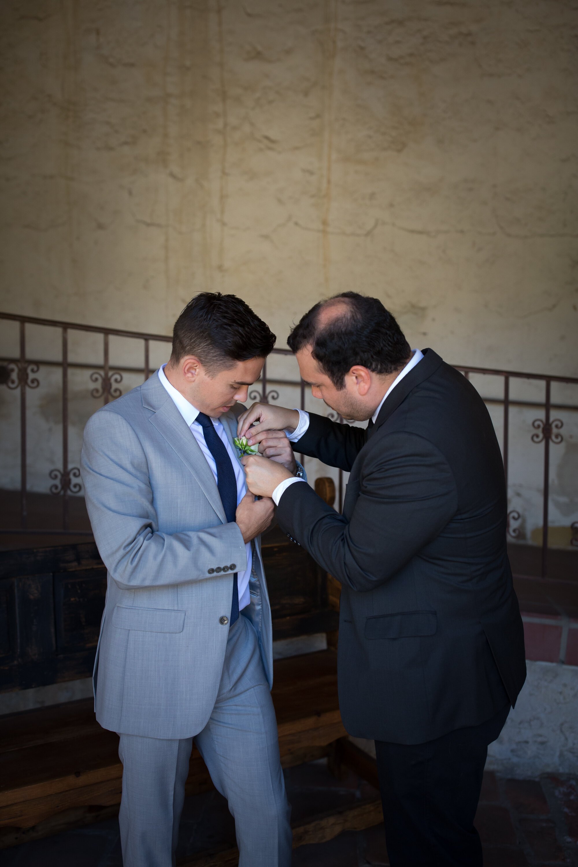 www.santabarbarawedding.com | Kelsey Crews Photo | Santa Barbara Mission | Ella &amp; Louie | Best Man Helping Groom with Boutonnière 