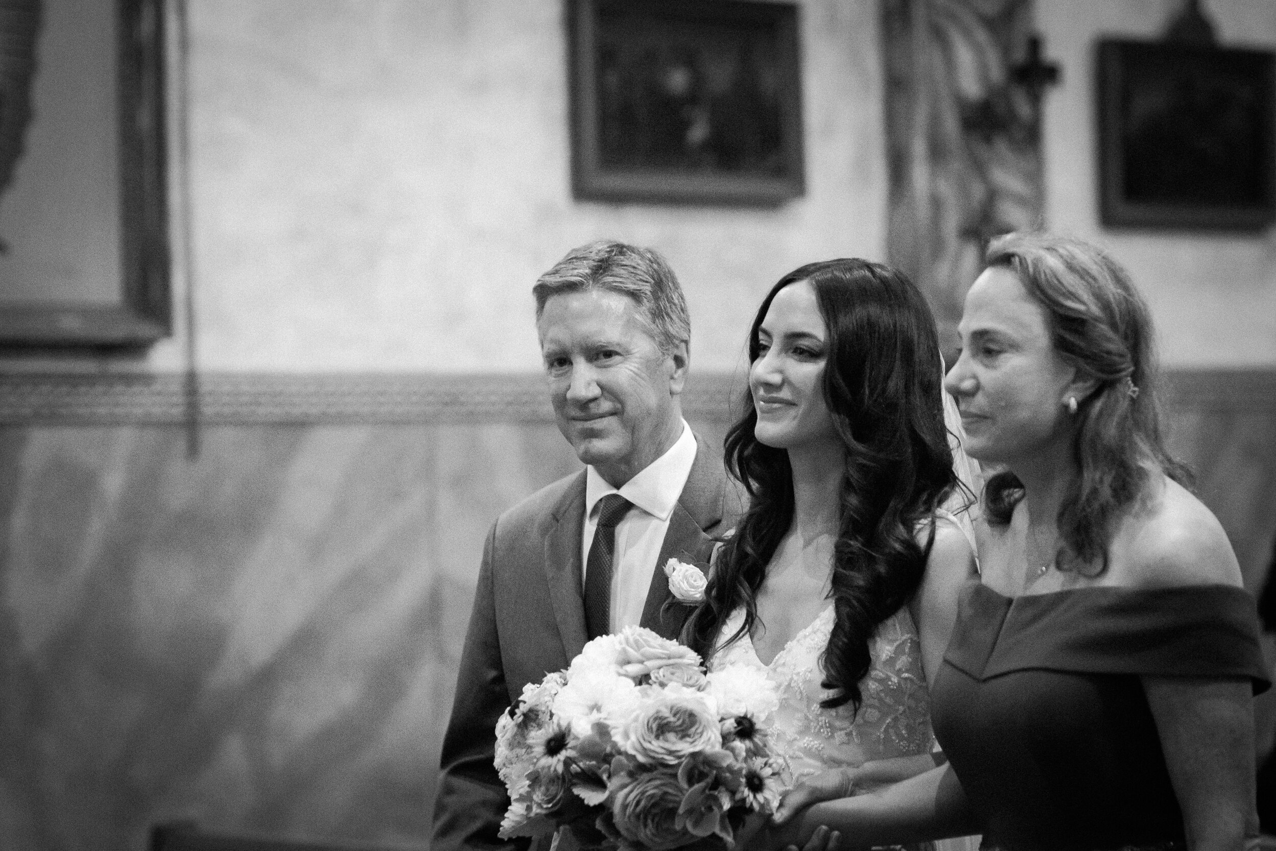 www.santabarbarawedding.com | Kelsey Crews Photo | Santa Barbara Mission | Ella &amp; Louie | Bride Walking Down Aisle with Her Parents