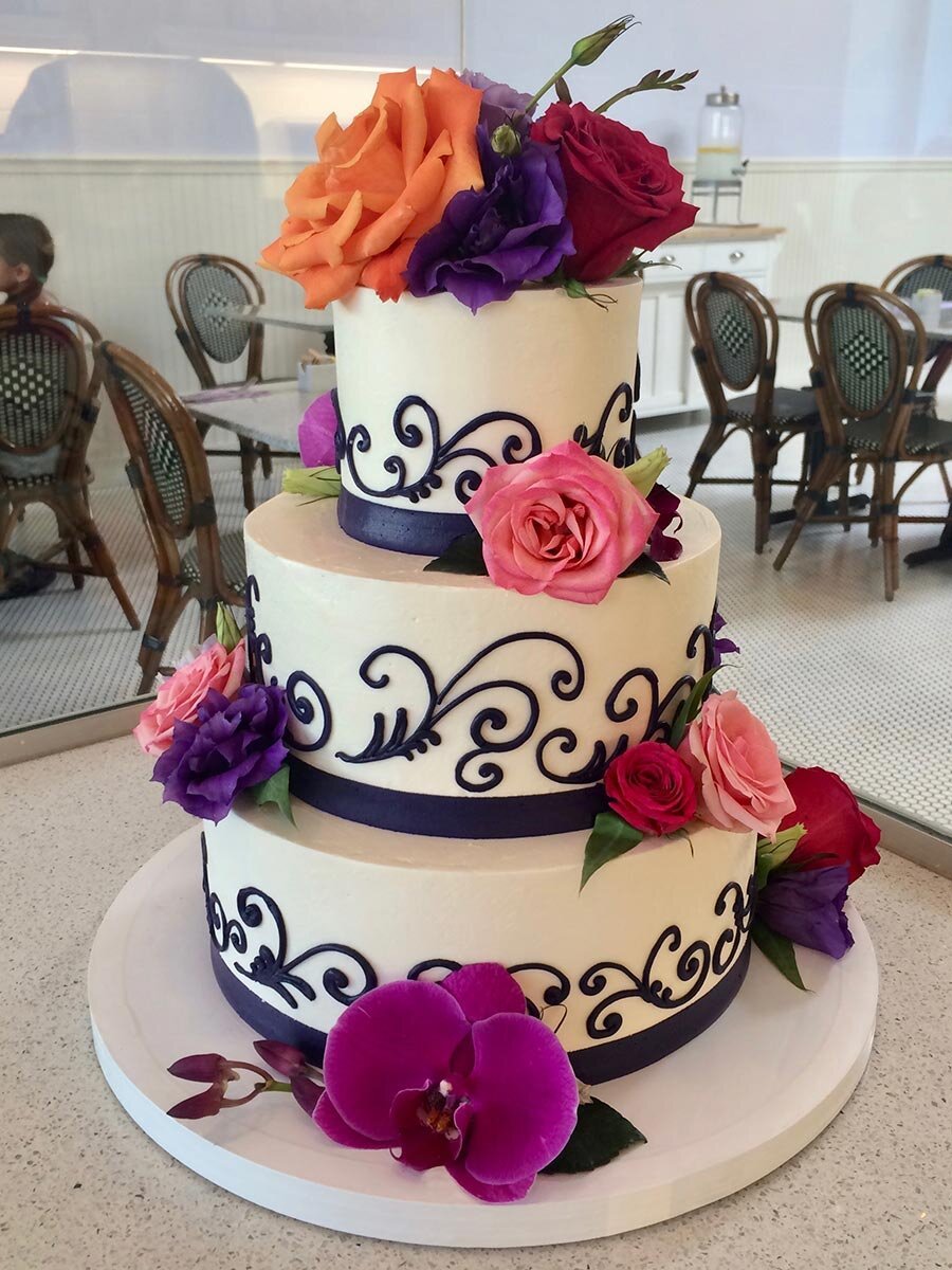 www.santabarbarawedding.com | Lilac Patisserie | White Three-Tiered Wedding Cake with Black Swirls and Orange, Pink, and Purple Flowers