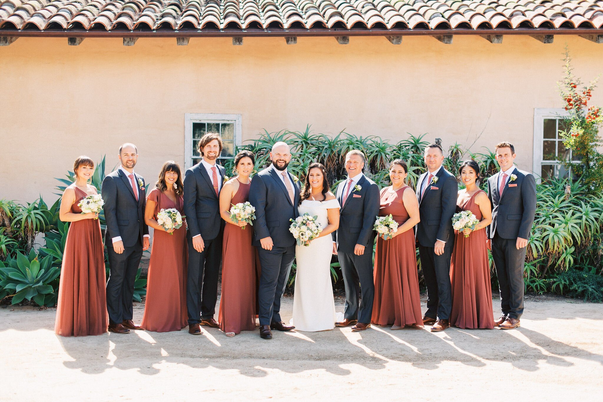 www.santabarbarawedding.com | Santa Barbara Historical Museum | Grace Kathryn Photography | Couple and Wedding Party with Burnt Orange Dresses Under the Tiled Roof 