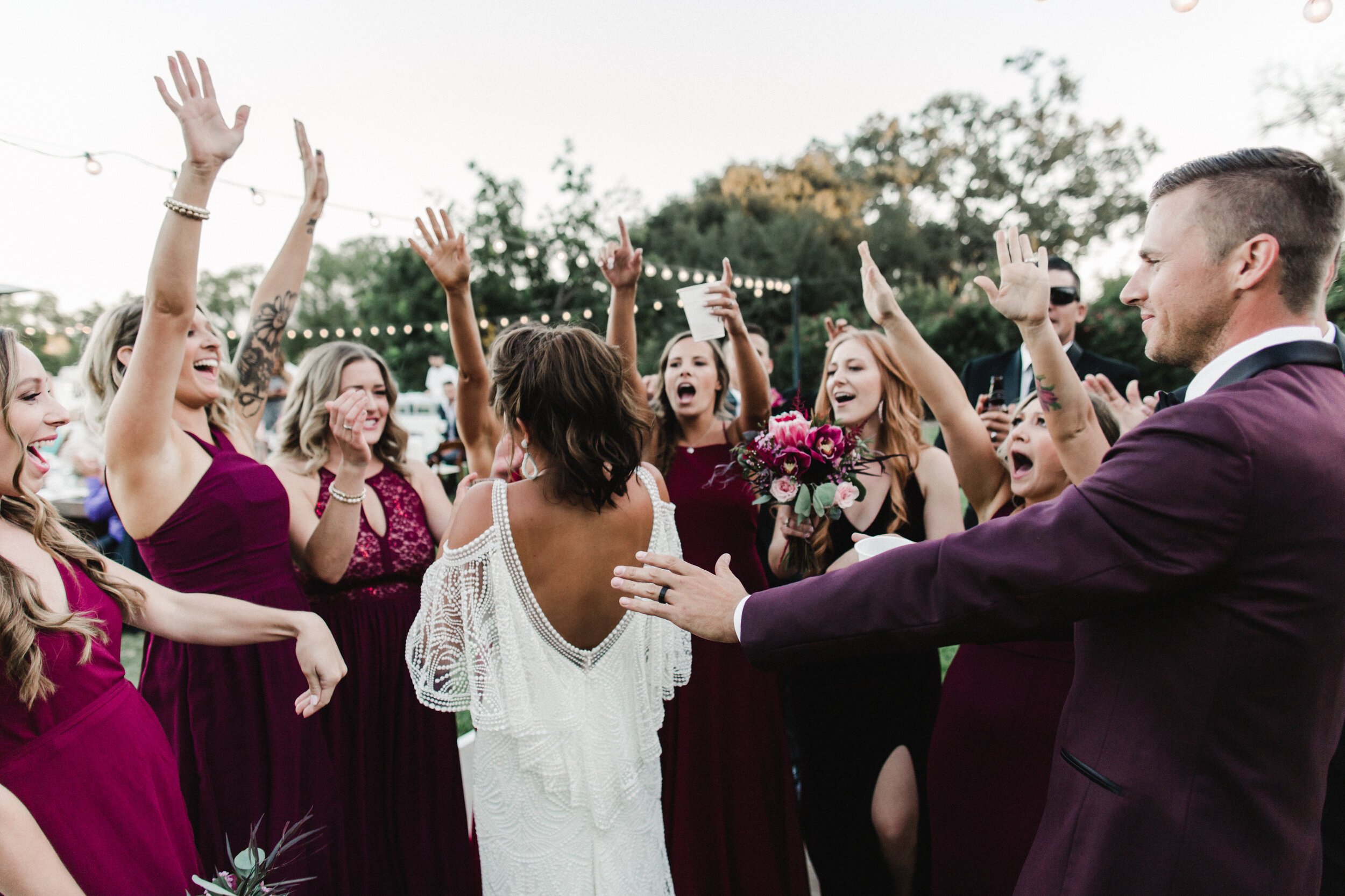 www.santabarbarawedding.com | Wunderland &amp; Co. | Rhianna Mercier Photography | Bride and Groom at Reception with Wine Colored Bridesmaid Dresses and Suits