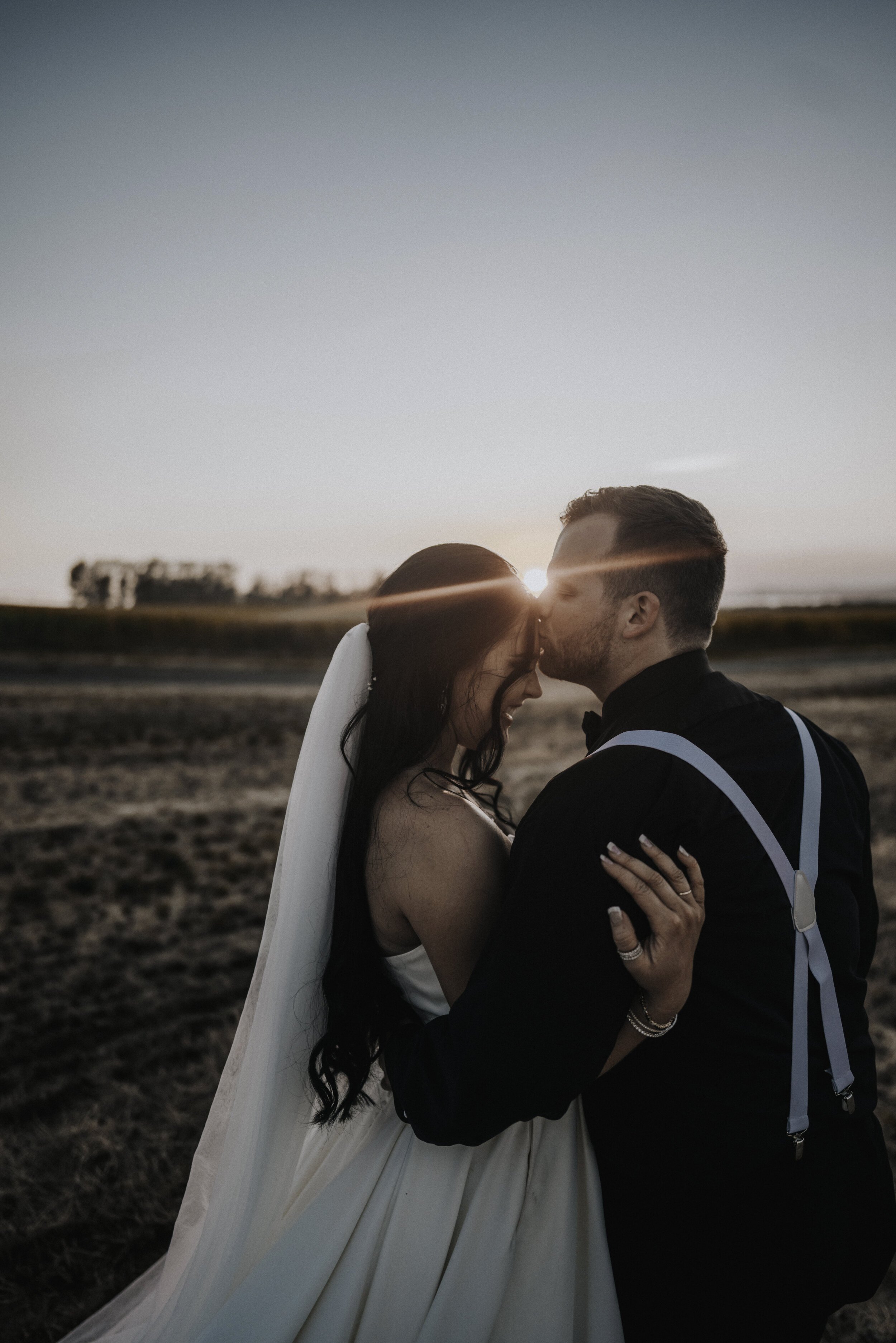 www.santabarbarawedding.com | Golden Glow Weddings | Bride and Groom Kiss in a Field at Sunset