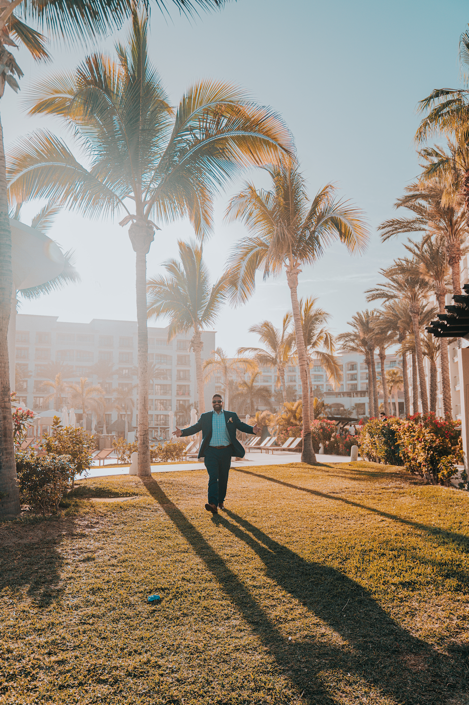 www.santabarbarawedding.com | Golden Glow Weddings | Groom Walking in Among the Palm Trees