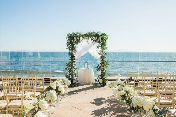 www.santabarbarawedding.com | Whitney Turner Photography | Ella &amp; Louie | Ceremony with the Ocean in the Background and White Floral Arrangements Lining the Aisle