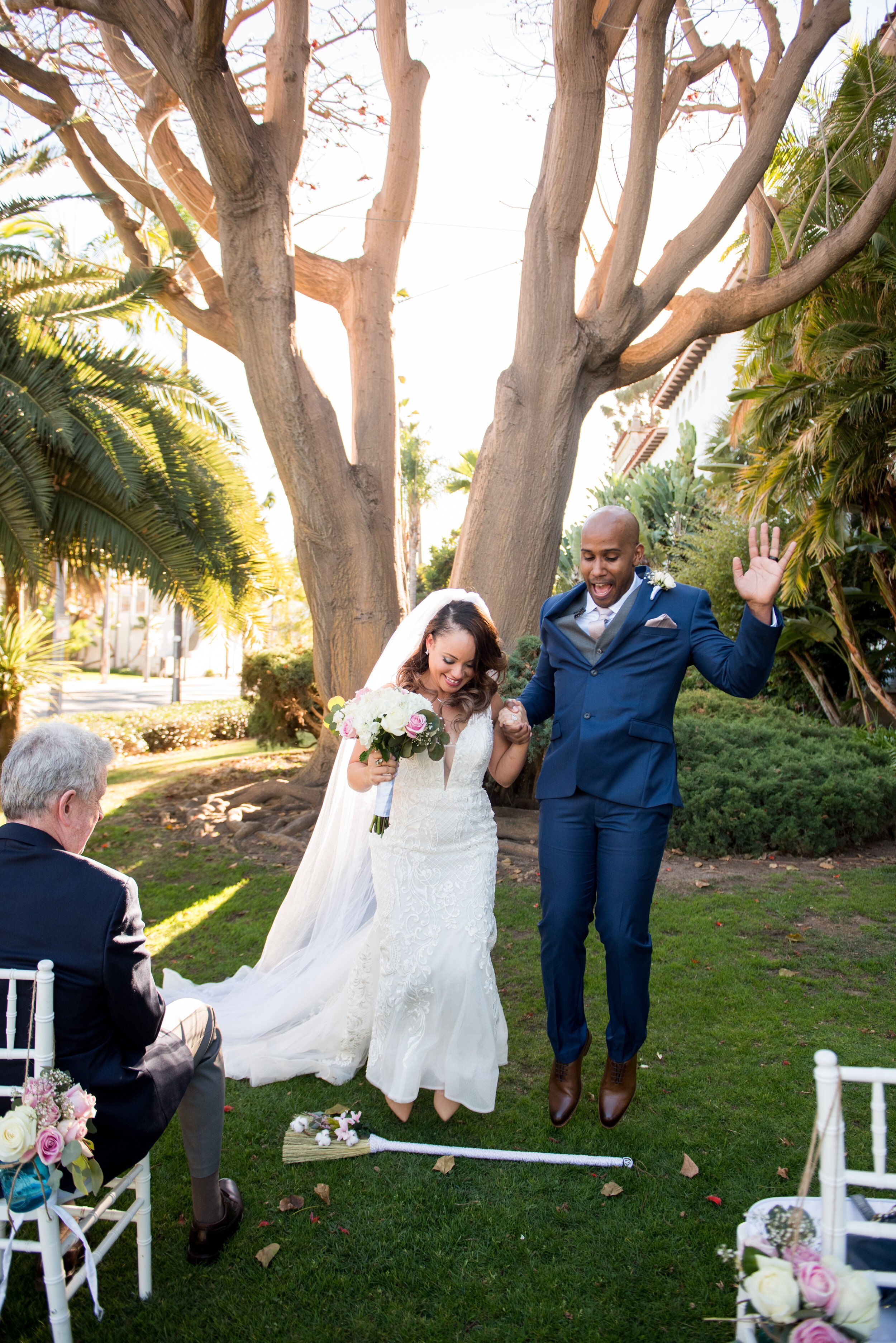 www.santabarbarawedding.com | ByCherry Photography | Santa Barbara Courthouse | Kaycee Dirkse | Ceremonies by Nanette | Santa Barbara Hair &amp; Makeup | Couple Jump Over Broom at Ceremony 