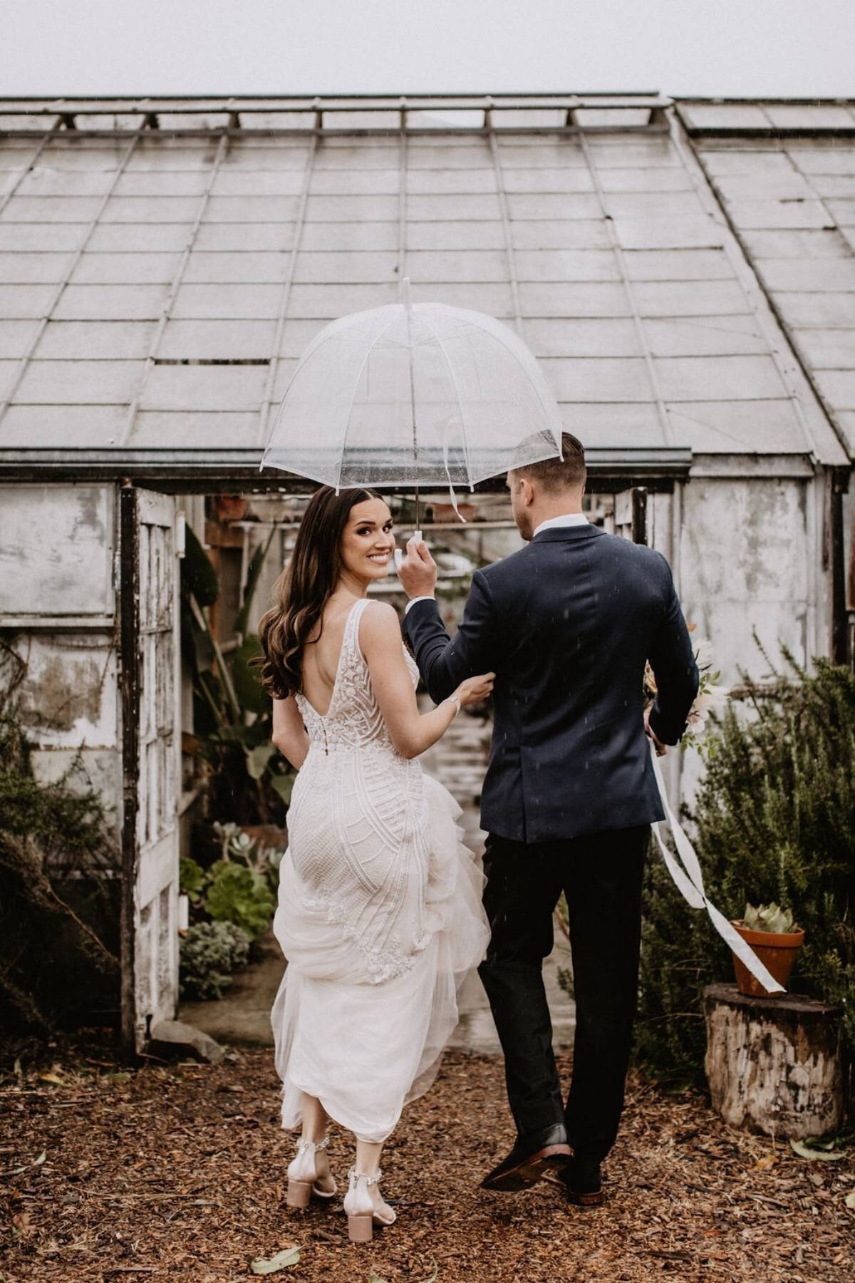 www.santabarbarawedding.com | White Sage Wedding and Events | We Are Matt + Jess | Dos Pueblos Orchid Farm | Badgley Mischka | Alexis Ireland Florals | Bride and Groom Under Umbrella