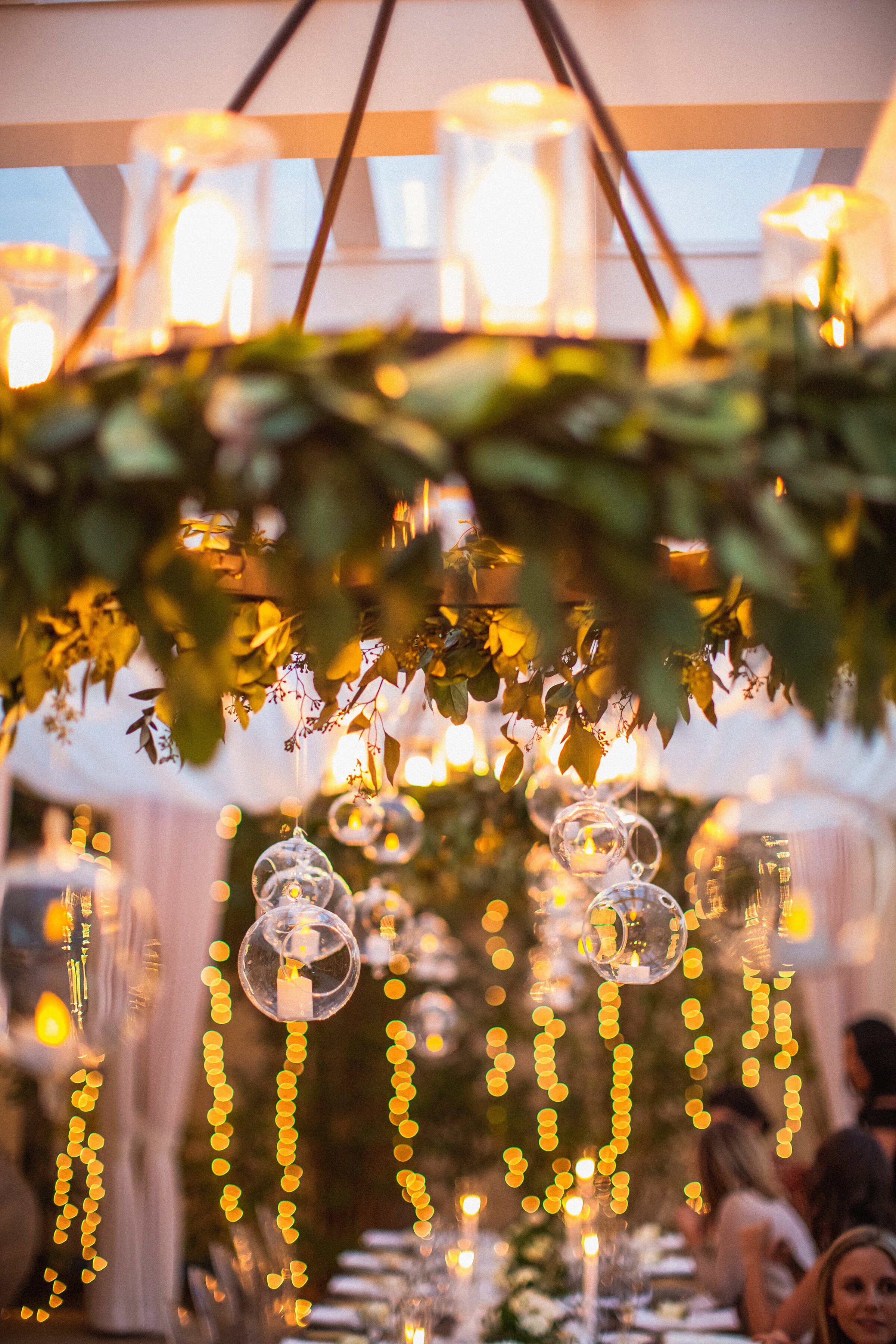 www.santabarbarawedding.com | Bella Vista Designs | Closeup of Chandelier and Glass Ball Lights Above Long Reception Table