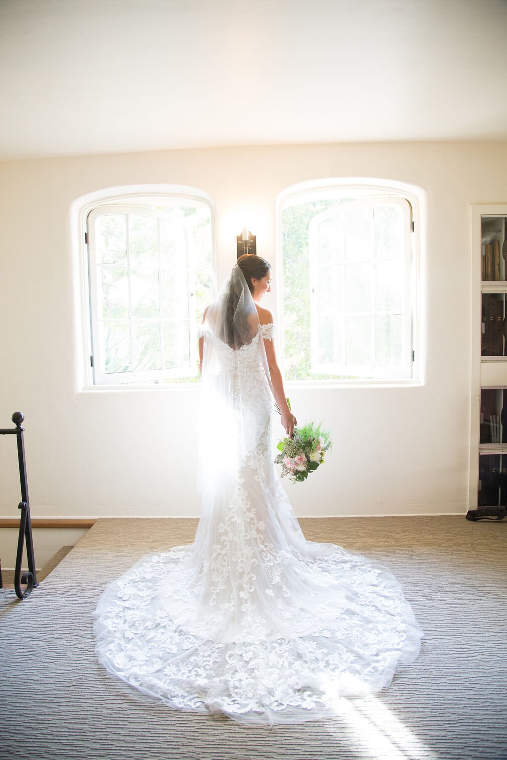 www.santabarbarawedding.com | Sarita Relis Photography | Felici Events | Rockwood Women’s Club | Alpha Floral | La Rouge Artistry | Bride Shows Off the Back of Her Dress