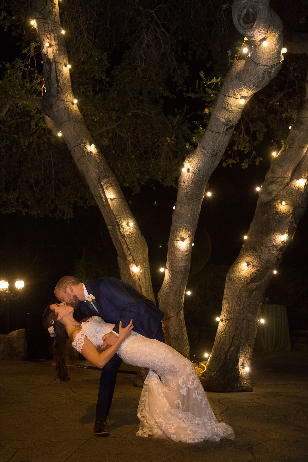 www.santabarbarawedding.com | Sarita Relis Photography | Felici Events | Rockwood Women’s Club | Alpha Floral | La Rouge Artistry | Groom Dips Bride in Front of Lit Tree