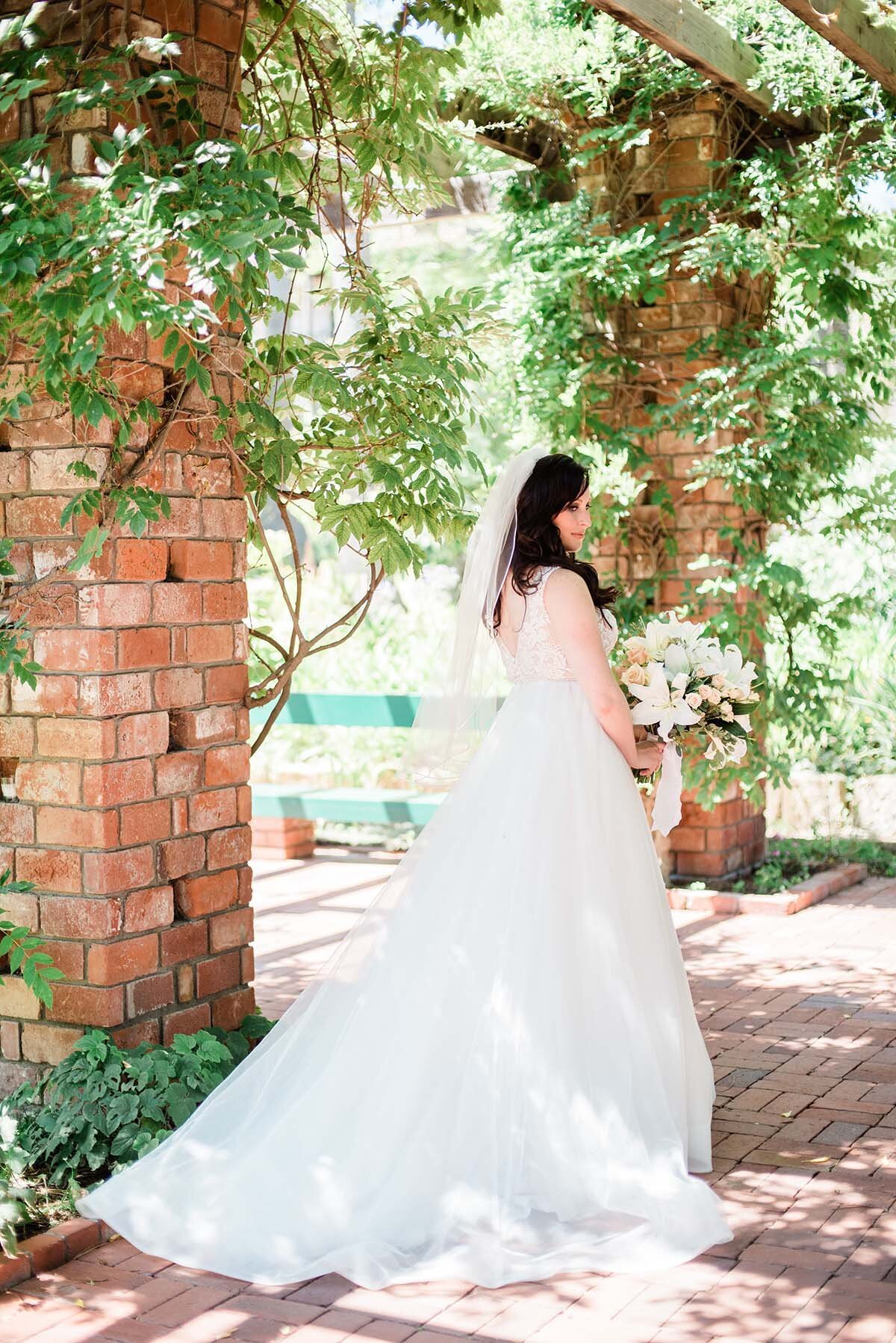 www.santabarbarawedding.com | ByCherry Photography | Belmond El Encanto | Hogue Floral | Santa Barbara Hair &amp; Makeup | Bride Showing Off the Back of Her Wedding Gown