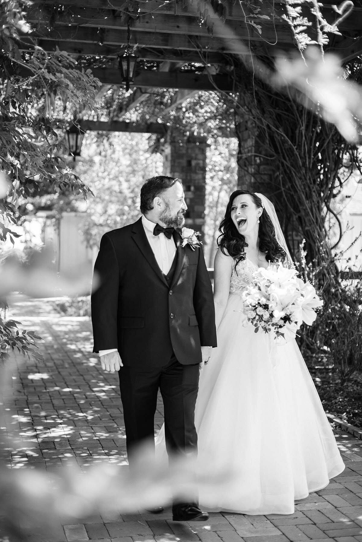 www.santabarbarawedding.com | ByCherry Photography | Belmond El Encanto | Hogue Floral | Santa Barbara Hair &amp; Makeup | Bride and Groom Laughing Under an Arch Walkway