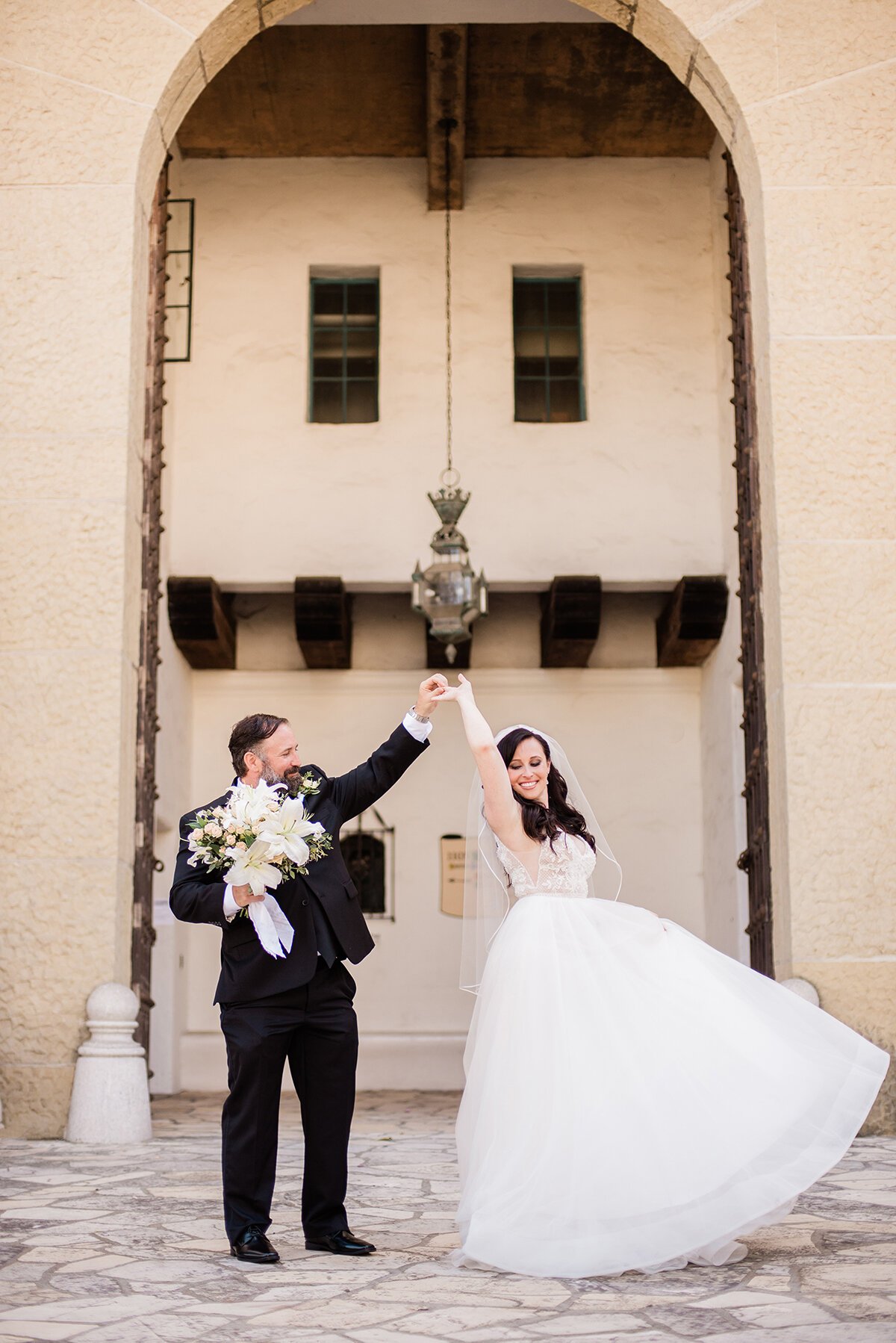 www.santabarbarawedding.com | ByCherry Photography | Santa Barbara Courthouse | Hogue Floral | Santa Barbara Hair &amp; Makeup | Groom Twirling the Bride in the Doorway