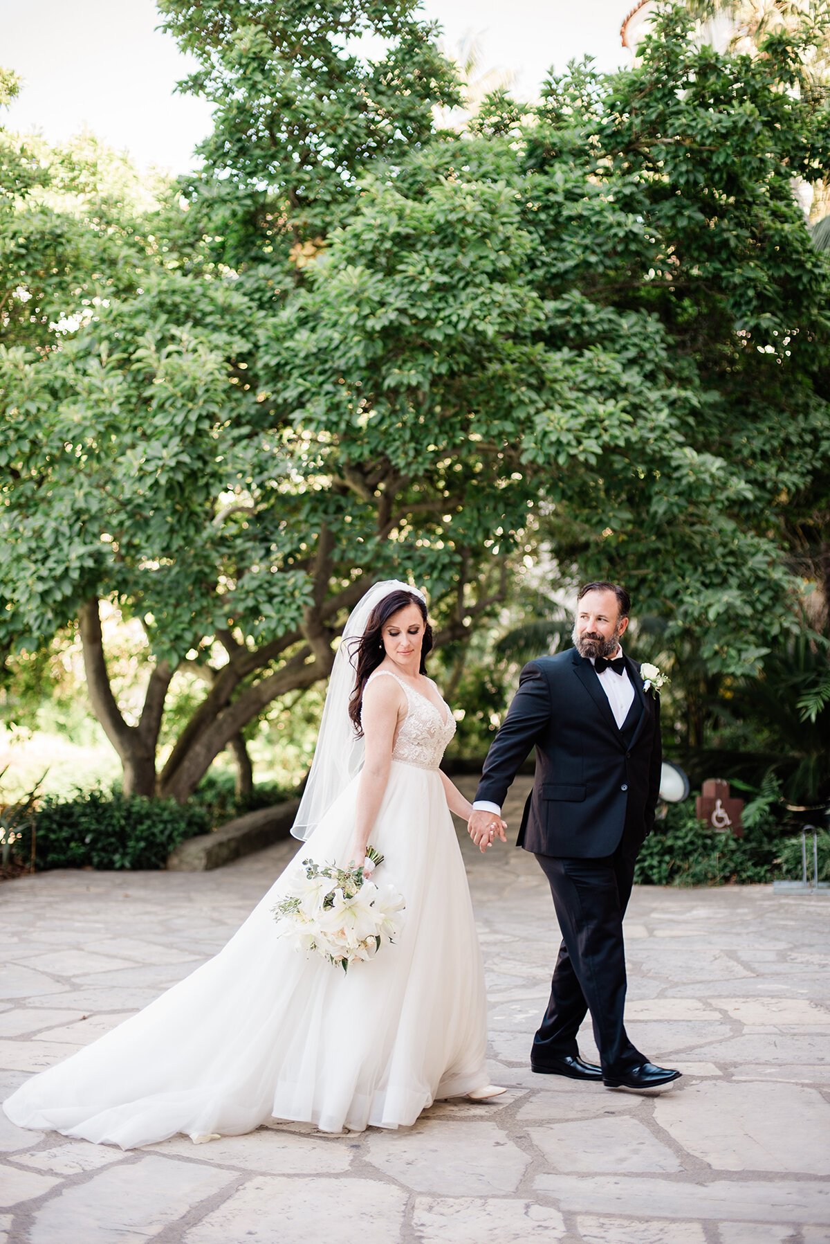 www.santabarbarawedding.com | ByCherry Photography | Santa Barbara Courthouse | Hogue Floral | Santa Barbara Hair &amp; Makeup | Bride and Groom Walking on the Stone Path