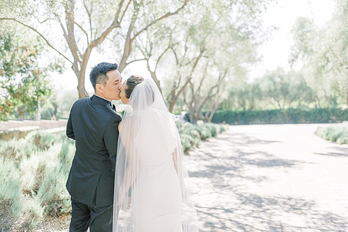 www.santabarbarawedding.com | Jocelyn &amp; Spencer | El Montecito Presbyterian Church | Lulus | Indochino | Bride and Groom Share a Kiss Outside by the Trees