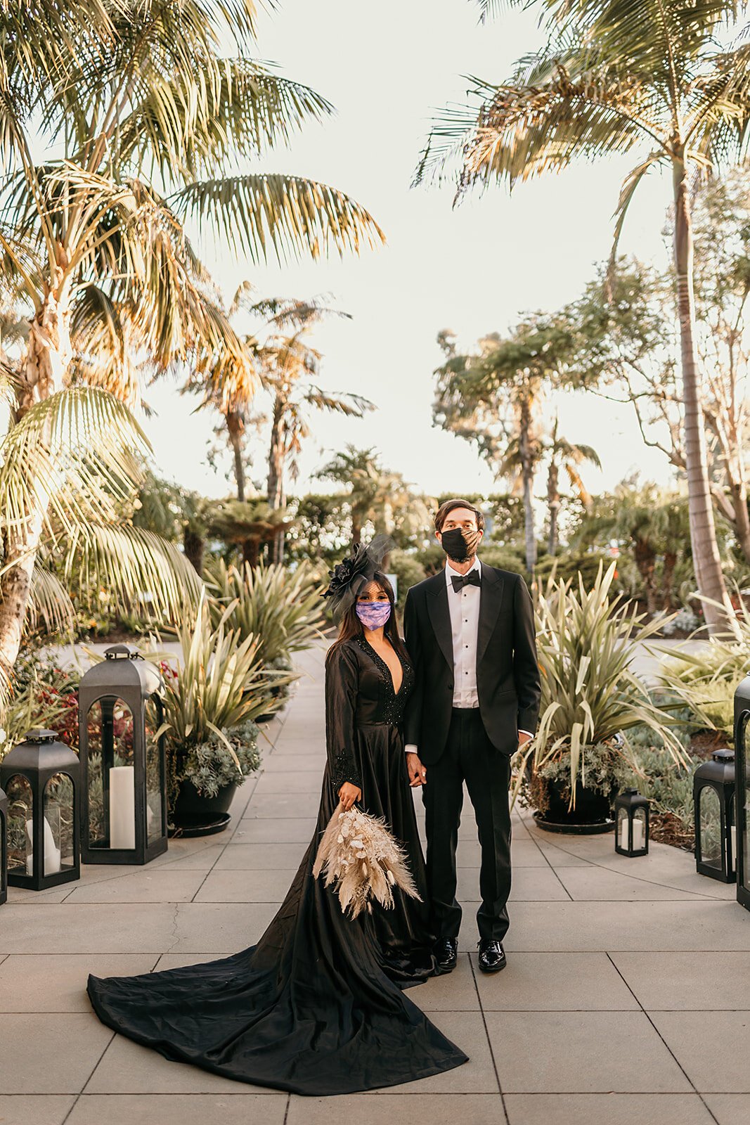 www.santabarbarawedding.com | Sarah Vendramini | The Ritz-Carlton Bacara | Lobo Floral | Mark Patterson | Bride and Groom with Their Masks On Among the Palm Trees