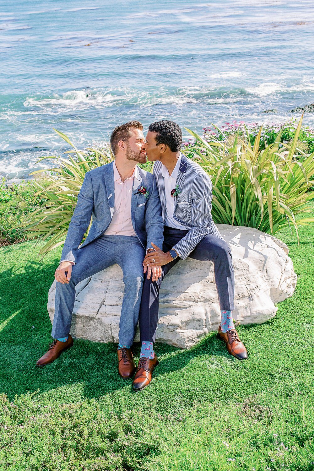 www.santabarbarawedding.com | Renoda Campbell Photography | Renoda Campbell Events | Men’s Wearhouse | Flourish Event &amp; Floral Design | Grooms Kiss on a Rock with the Ocean in the Background