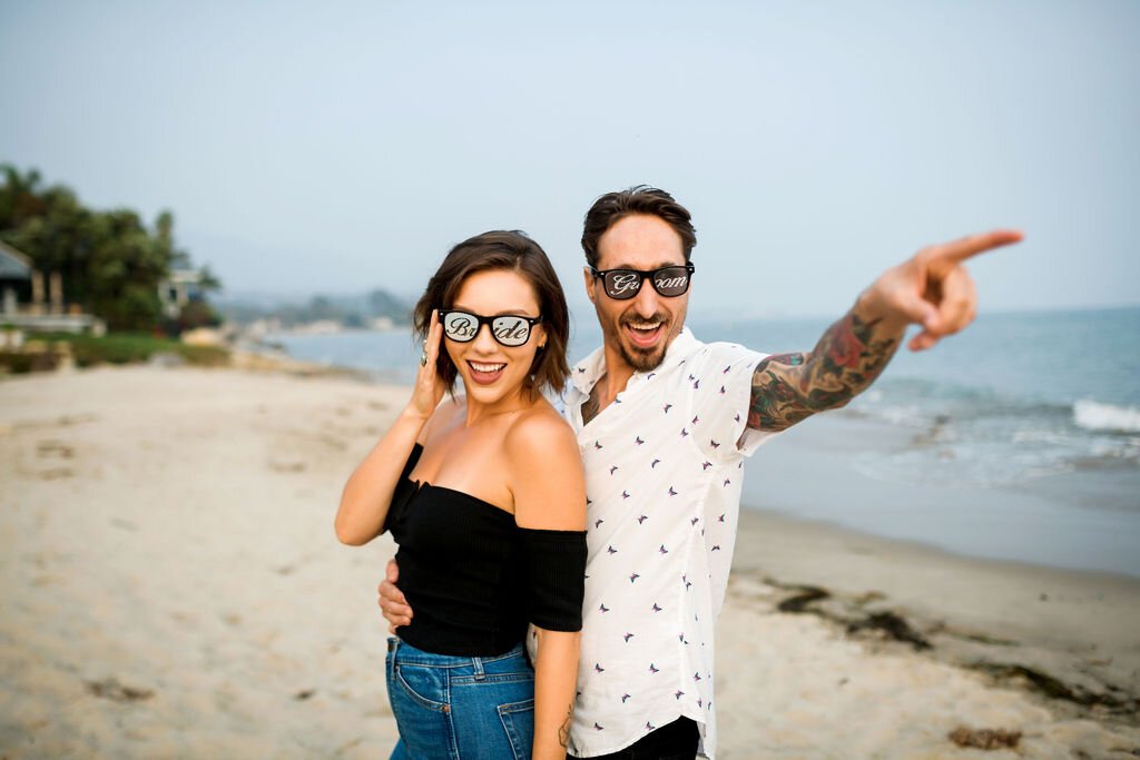 www.santabarbarawedding.com | Montecito | Julia Franzosa Photography | Engagement Photo of the Couple Wearing Bride and Groom Sunglasses on the Beach 