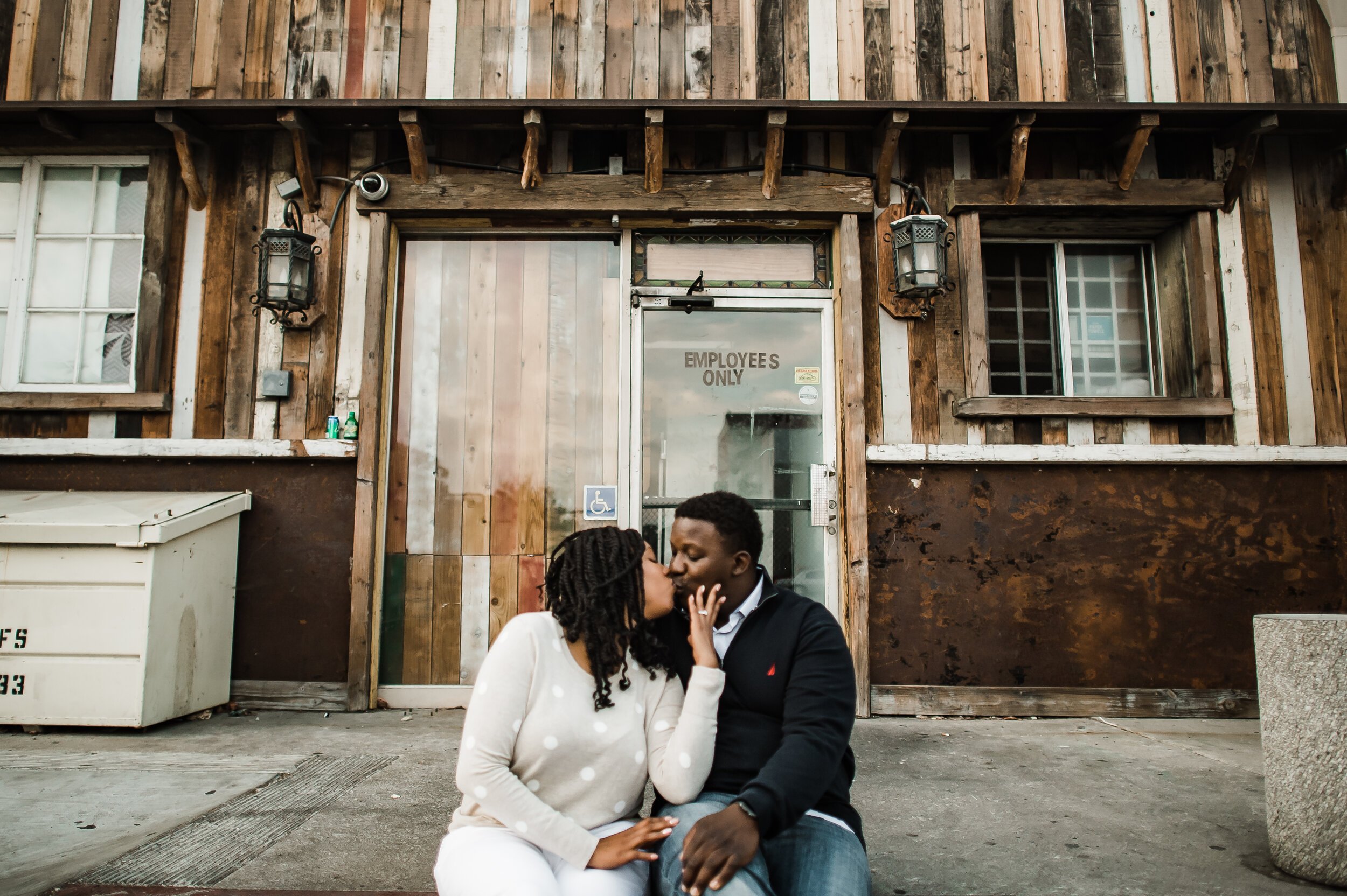 www.santabarbarawedding.com | Michelle Ramirez Photography | Couple Kisses in Front of Rustic Building in Downtown Ventura