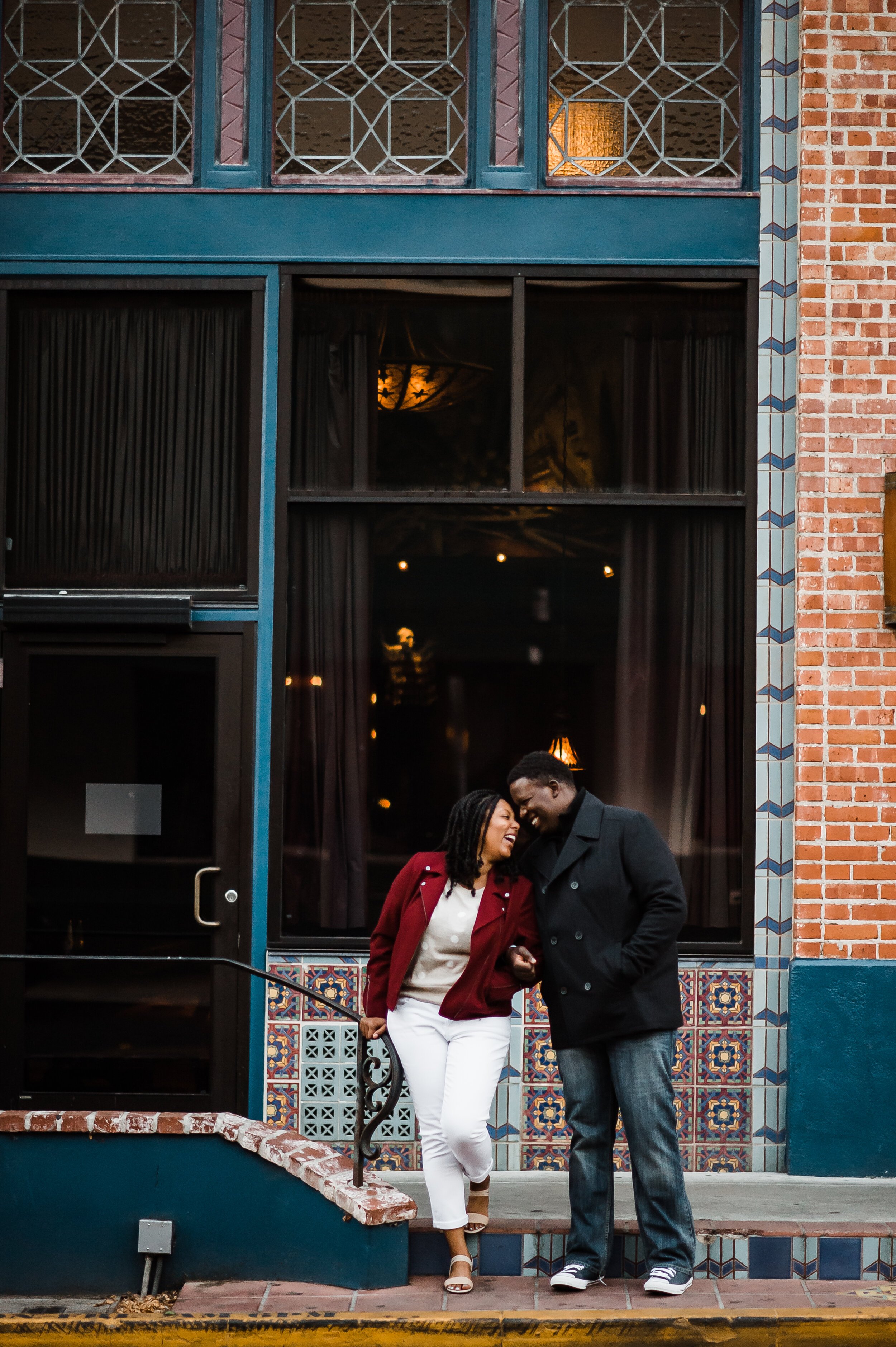 www.santabarbarawedding.com | Michelle Ramirez Photography | Couple Standing in Front of Colorful Building During Engagement Shoot in Downtown Ventura