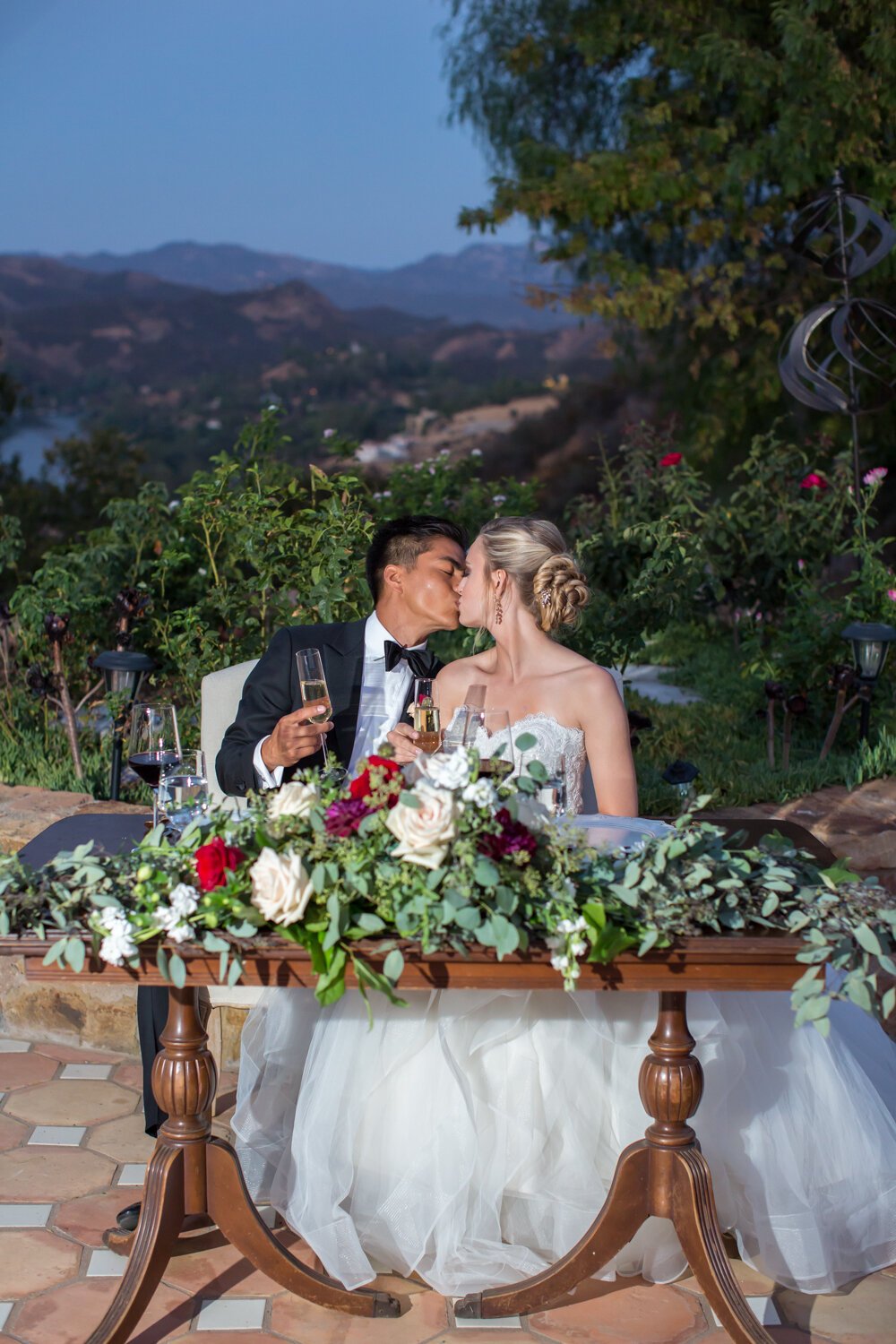 www.santabarbarawedding.com | APEX Malibu | Elizabeth Victoria Photography | Ebeling Events | Flowers by Maria | Amigo Party Rentals | Guiglielmo Winery | Couple Kiss at Reception Table 