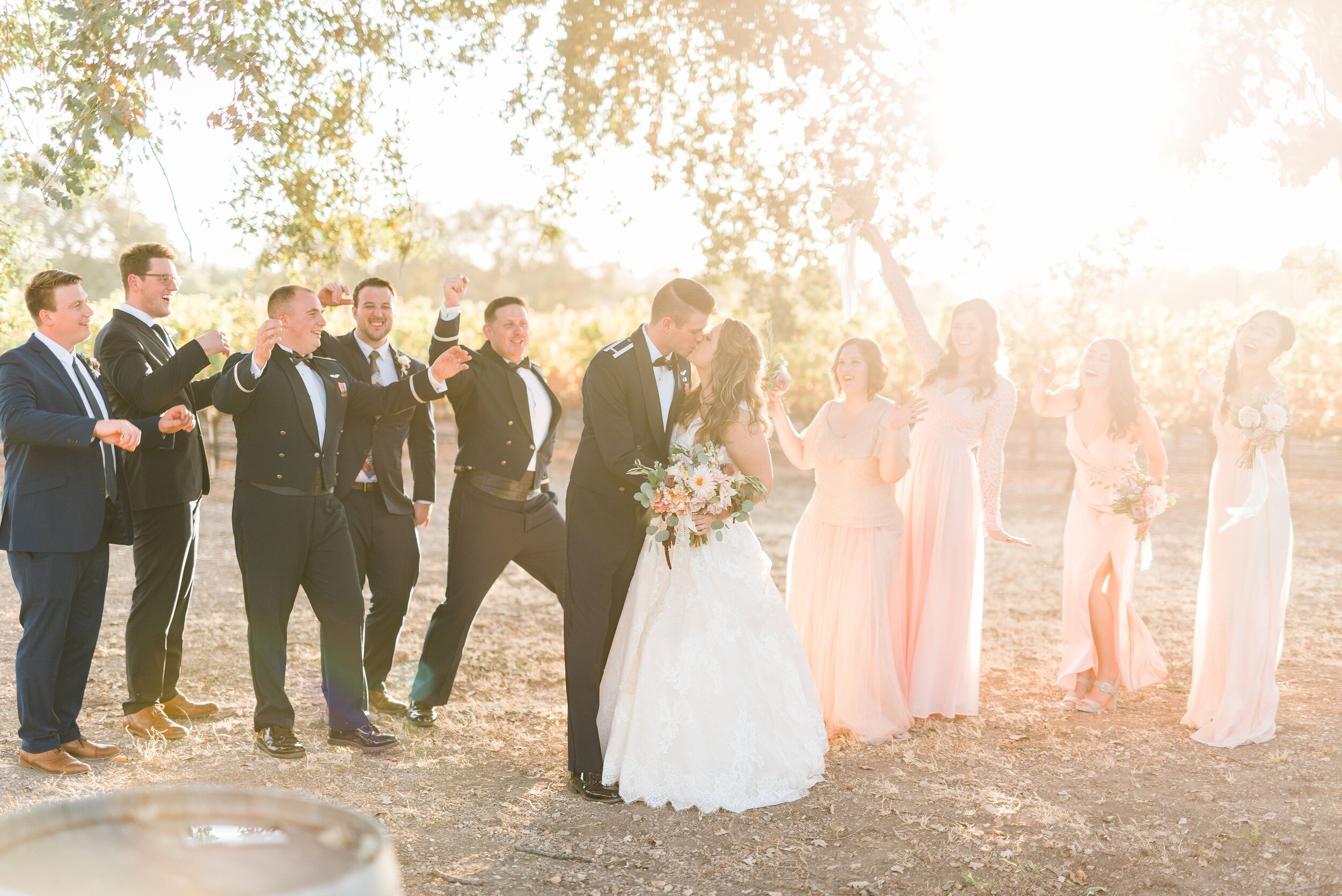 www.santabarbarawedding.com | Roblar Winery and Farm | Brittany Taylor Photography | Bride and Groom Kiss Surrounded by Wedding Party 
