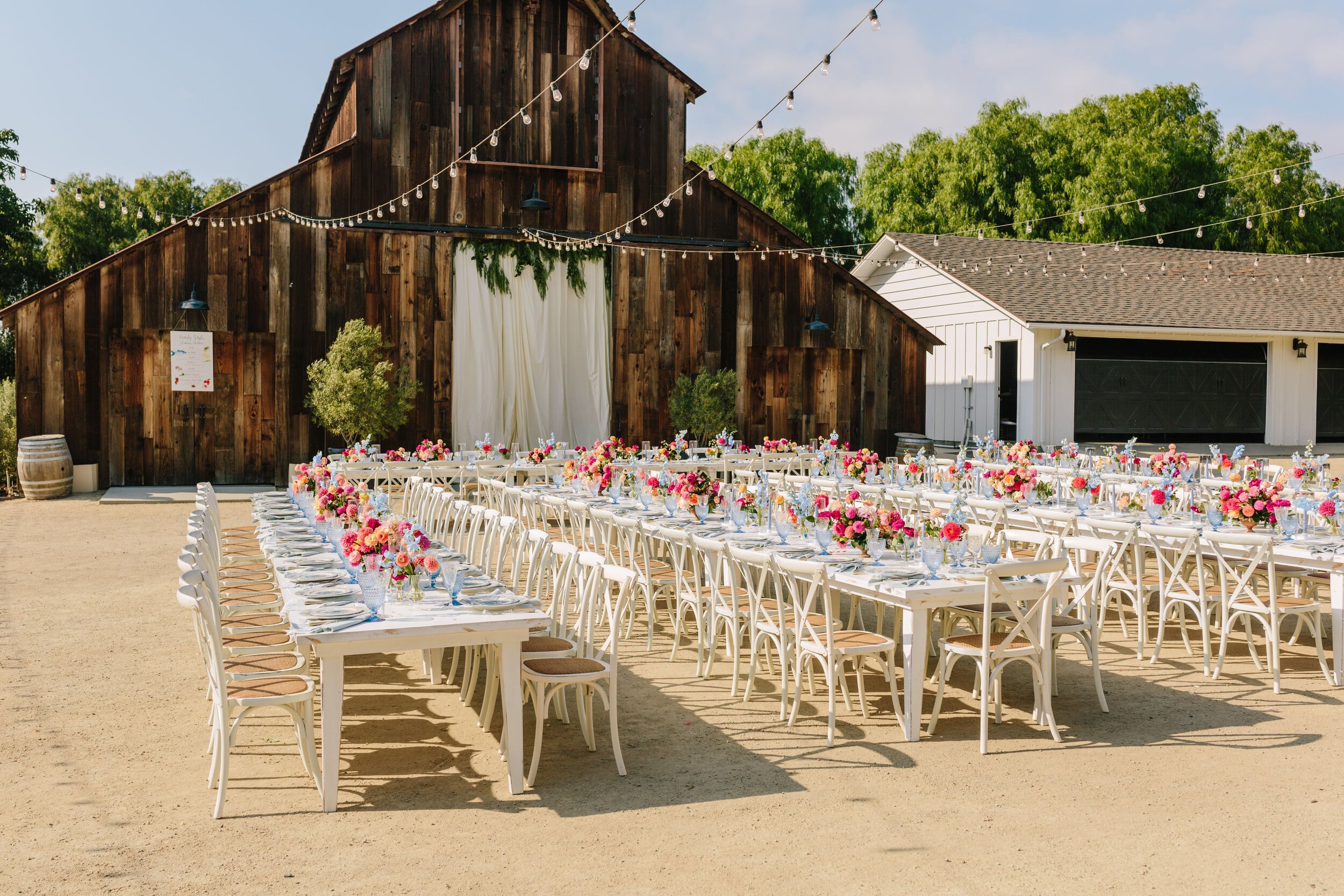 www.santabarbarawedding.com | Bright Event Rentals | Outdoor Reception with String Lights and a Barn Background 