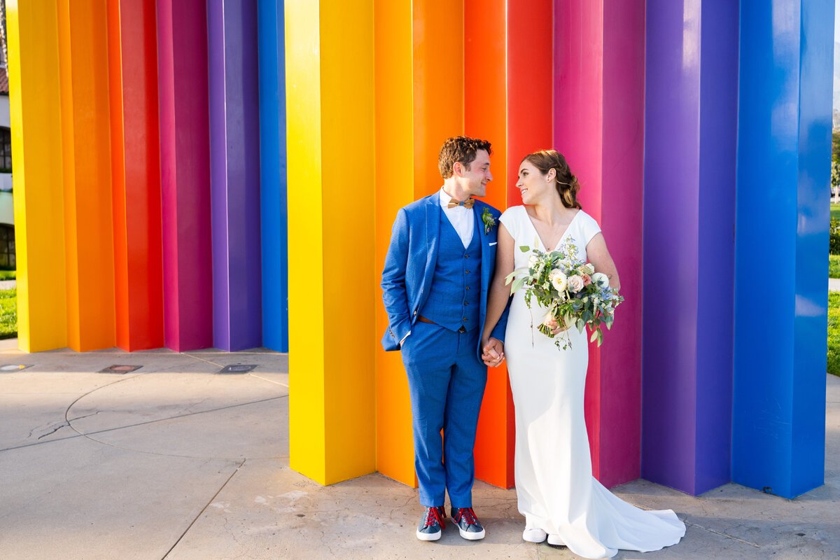 www.santabarbarawedding.com | Hilton SB Beachfront Resort | Peterson Design &amp; Photography | Kindred Weddings &amp; Events | The Twisted Twig | BHLDN | Couple in Front of Colorful Structure