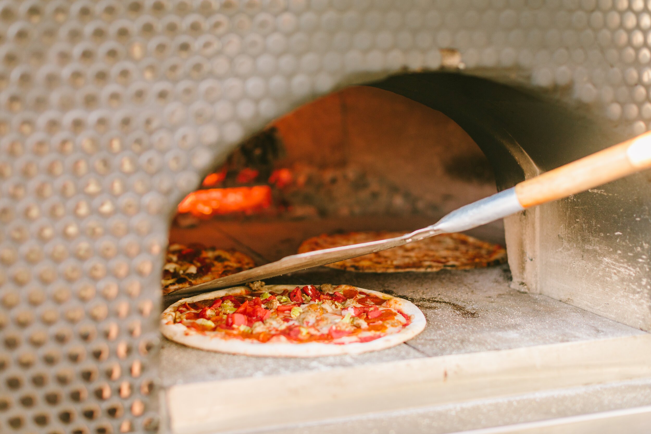 www.santabarbarawedding.com | Firefly Pizza Company | Pulling Pizza Out of the Oven 