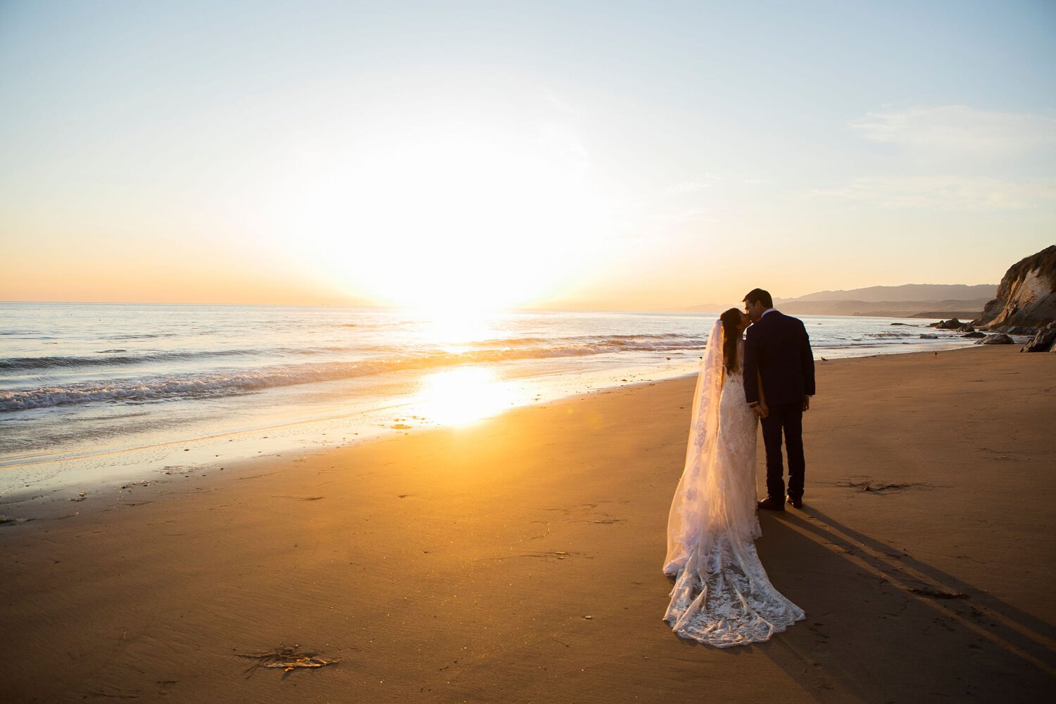 www.santabarbarawedding.com | Nightingale Photography | Rancho Dos Pueblos | Wild Hearts Events | Knot Just Flowers | TEAM Hair &amp; Makeup | Bride and Groom Kiss on the Beach