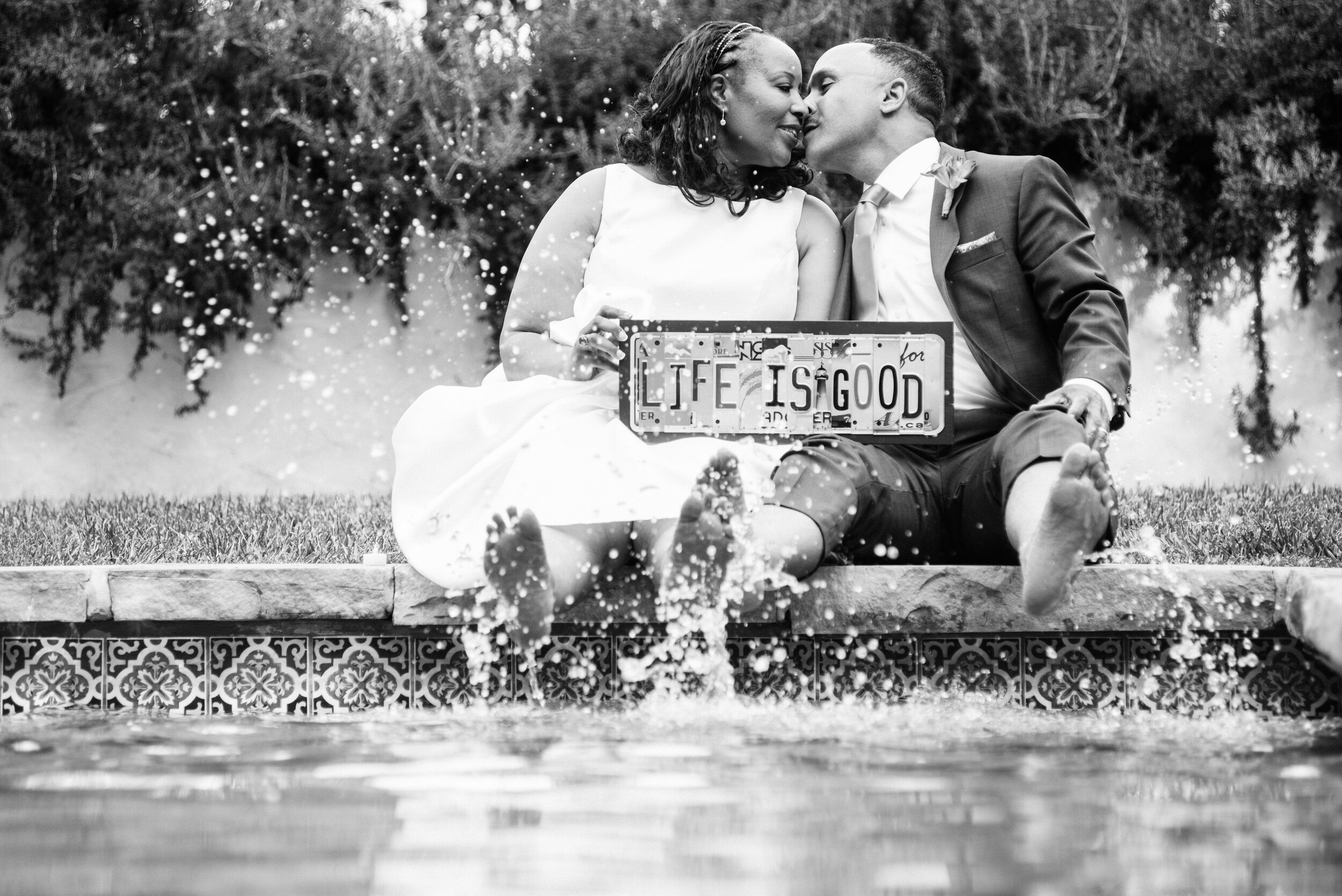 www.santabarbarawedding.com | ByCherry Photography | Riviera Productions | Bride and Groom with Life is Good Sign in Fountain