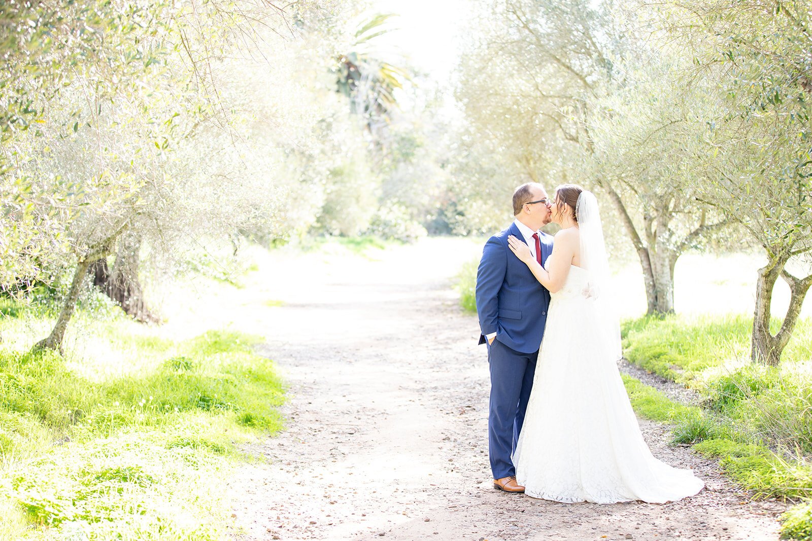 www.santabarbarawedding.com | Historic Rancho La Patera &amp; Stow House | Jocelyn &amp; Spencer | Woodland Events | The Bride and Groom Kiss on a Light Path