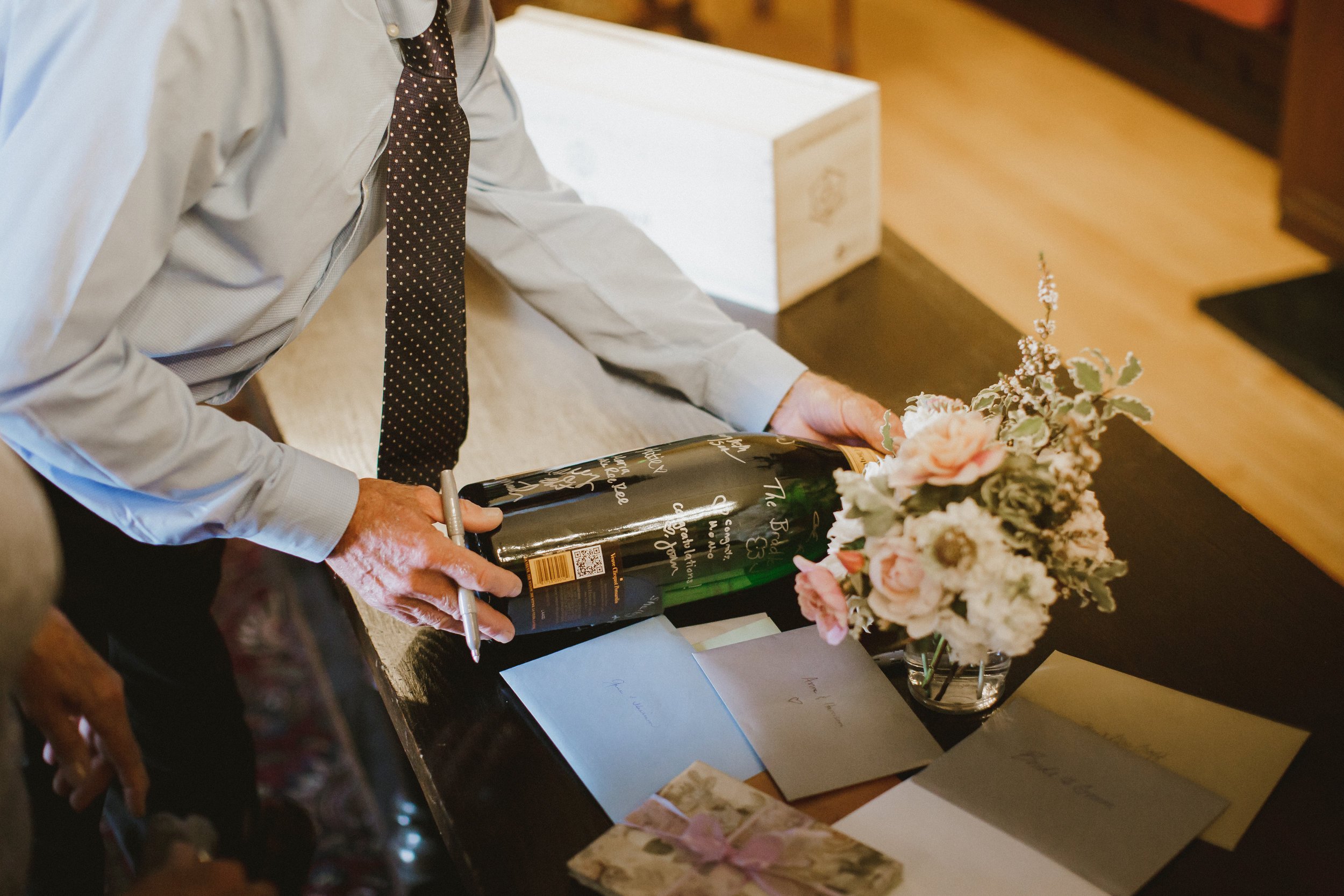 www.santabarbarawedding.com | Ryanne Bee Photography | The Santa Barbara Club | Haute Blossoms Floral | Signed Wine Bottle with Flowers