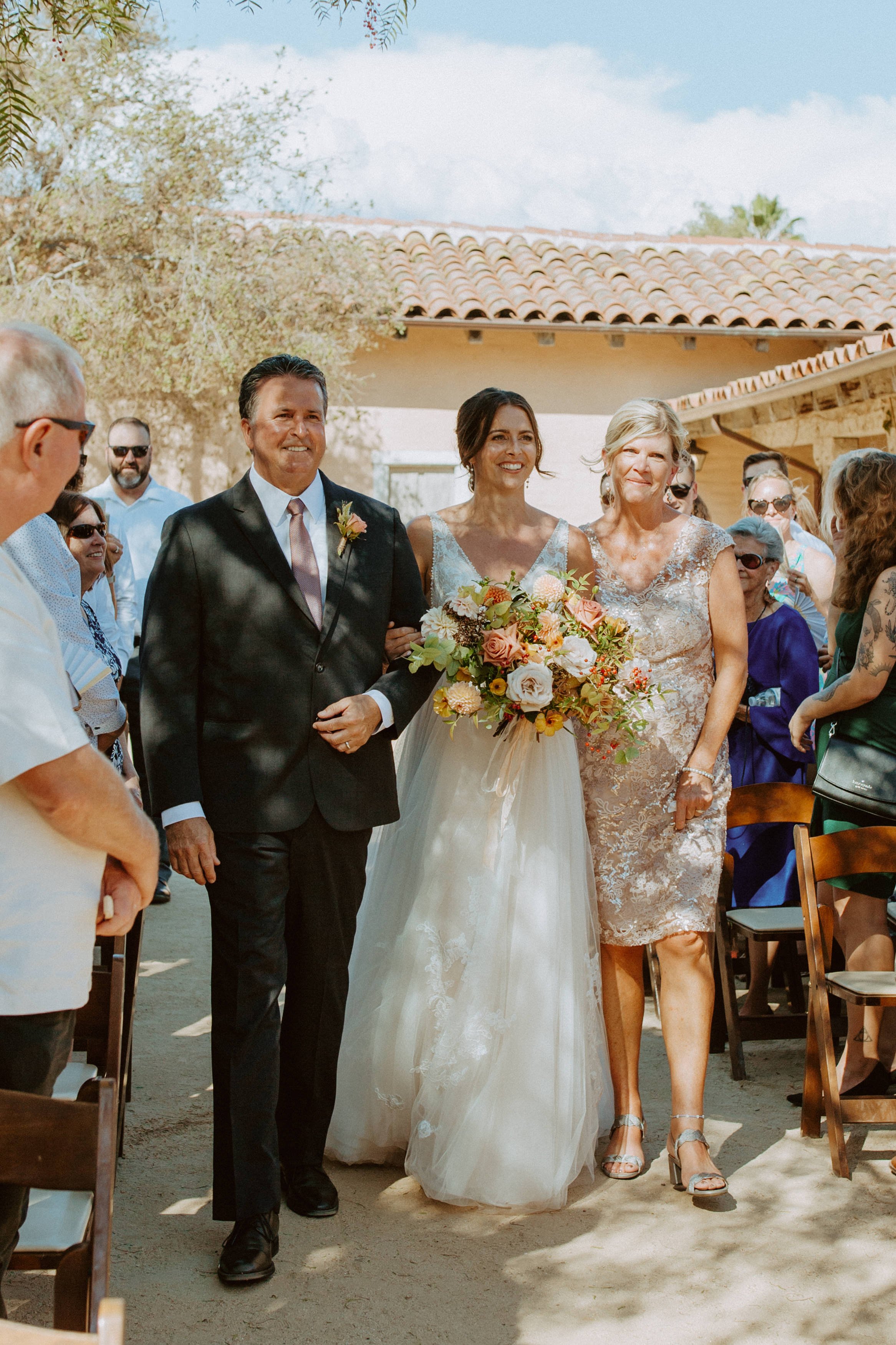 www.santabarbarawedding.com | Alyssa Brown | SB Historical Museum | Ann Johnson Events | Alexis Ireland Florals | Ventura Rental | Bride Walking Down Aisle with Parents