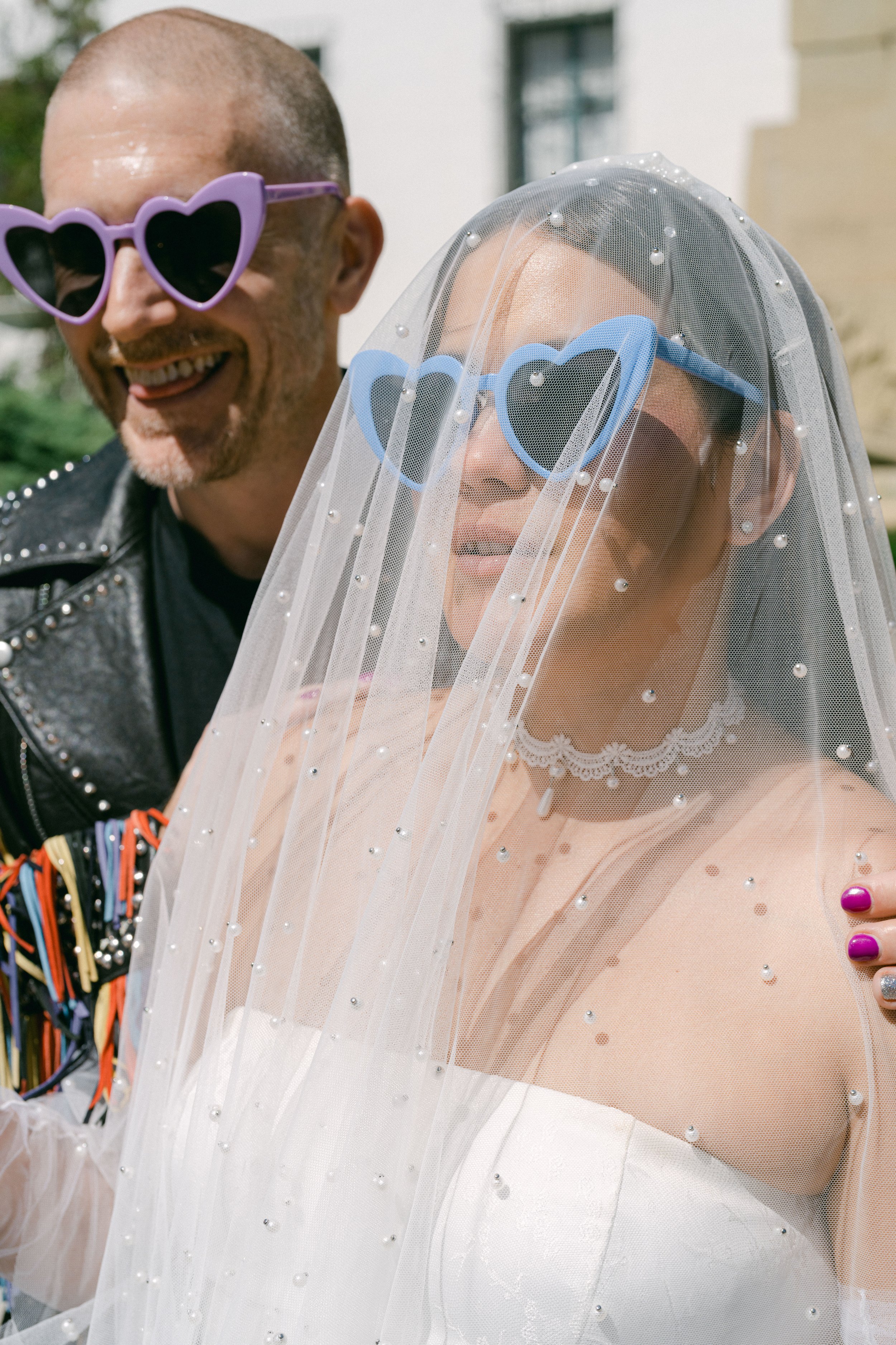 www.santabarbarawedding.com | Santa Barbara Courthouse | The Bomani’s | Couple Embracing Outside in Their Heart Sunglasses