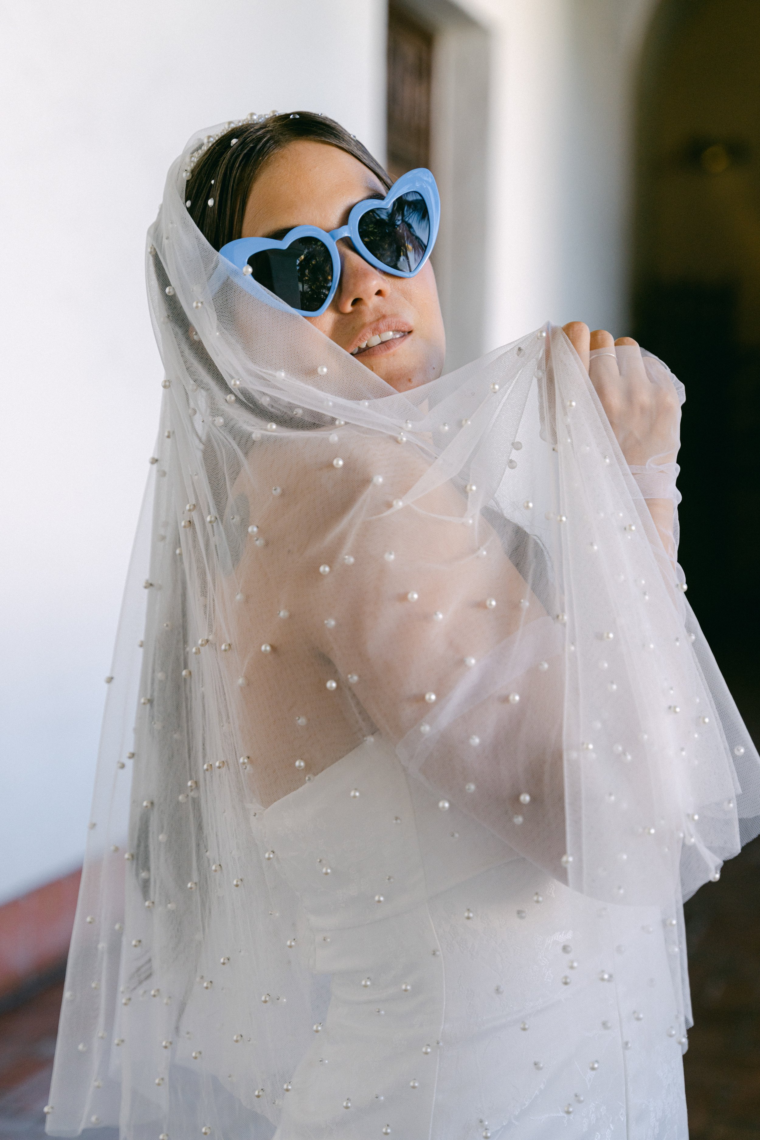 www.santabarbarawedding.com | Santa Barbara Courthouse | The Bomani’s | Bride Posing with Veil and In Her Blue Heart-Shaped Sunglasses