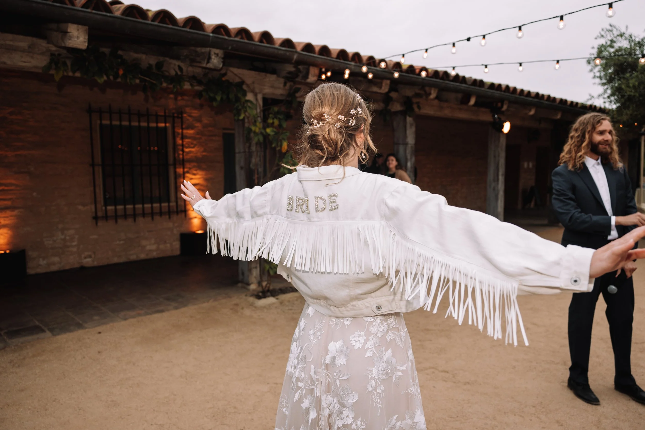 www.santabarbarawedding.com | Bear Beau | SB Historical Museum | Tangled Lotus | KB Events | La Rouge Artistry | Bride Showing Off Jacket