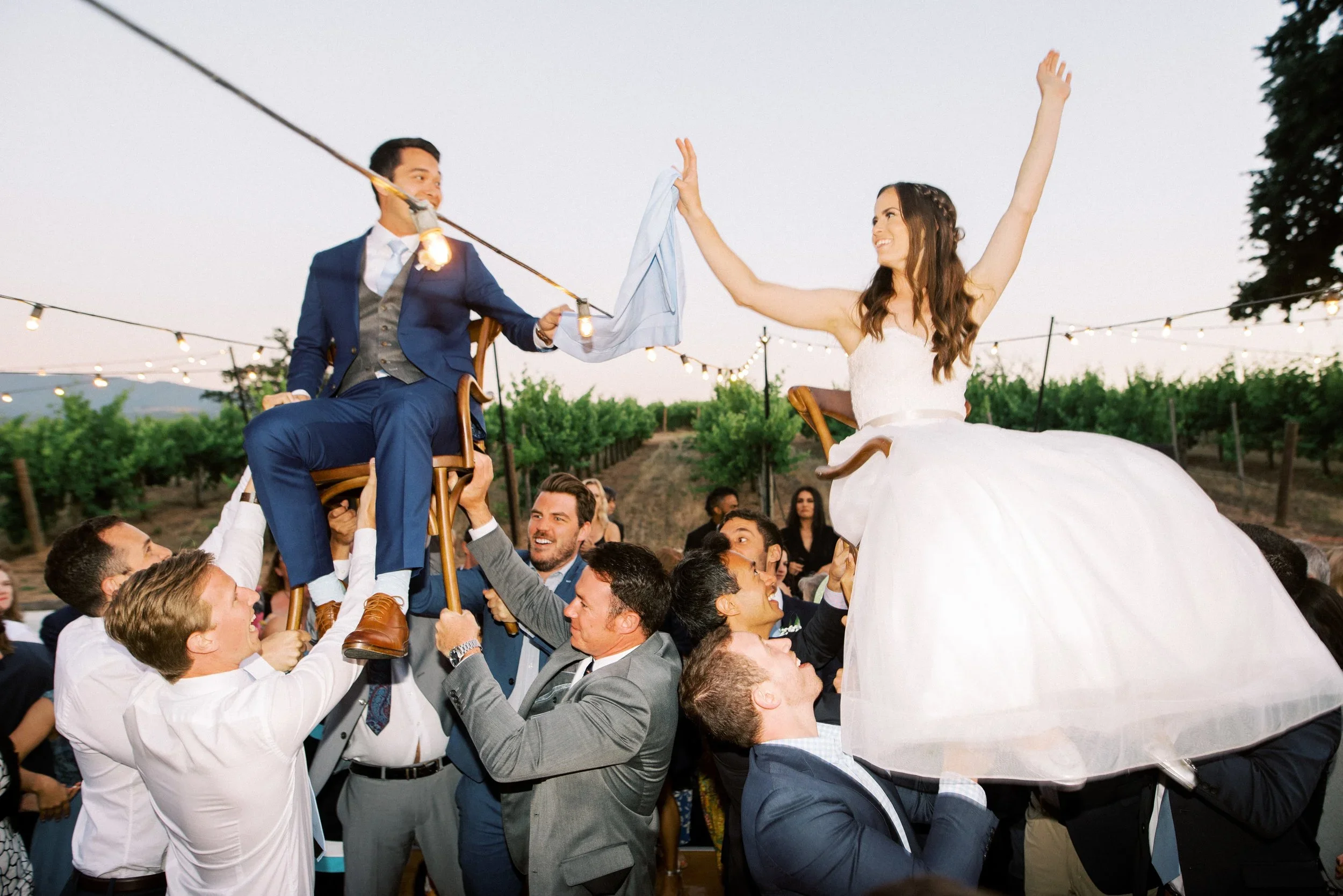 Bride and groom lifted up for Hora Jewish wedding tradition