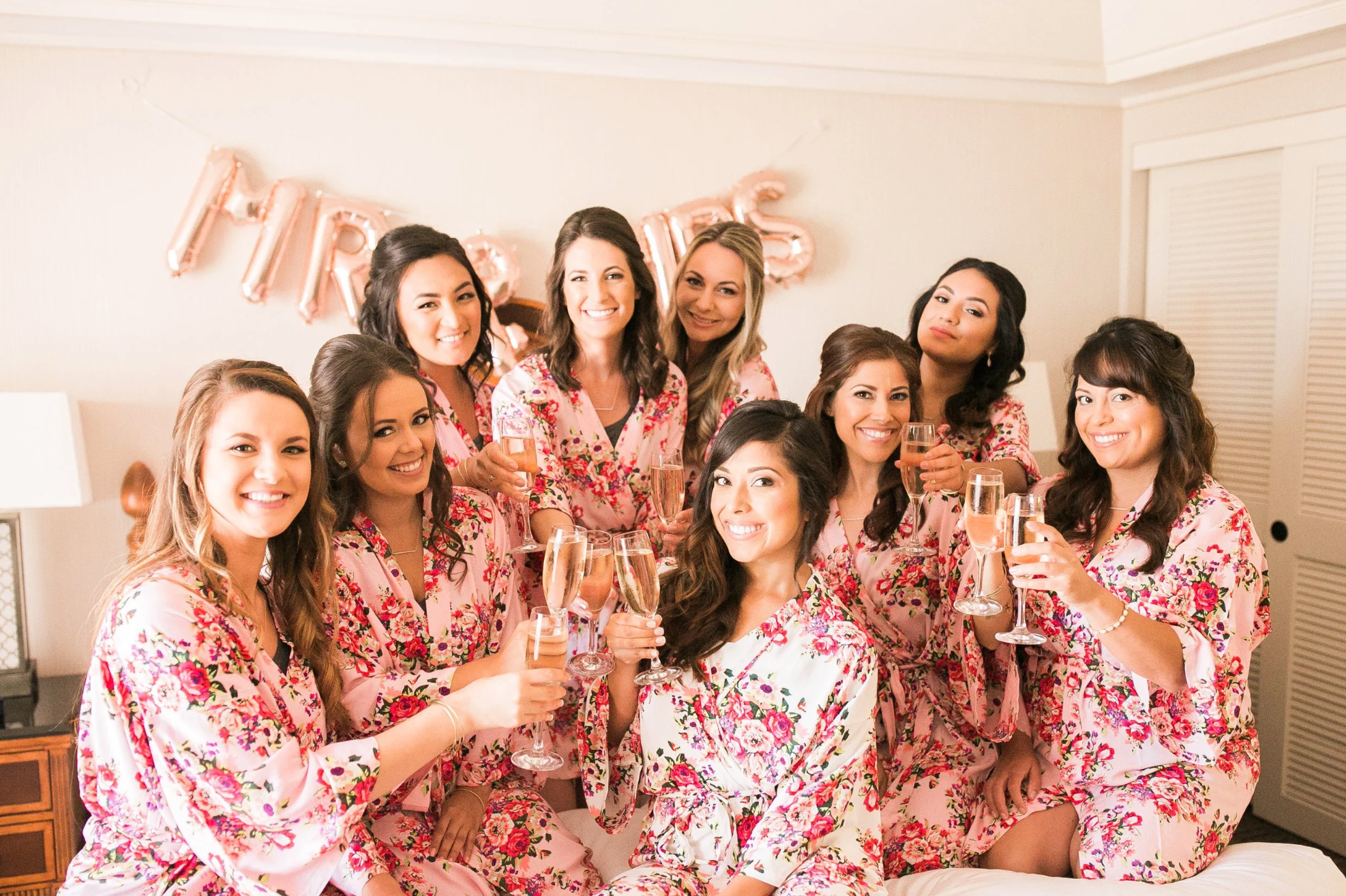 Bride and bridesmaids drinking champagne in robes